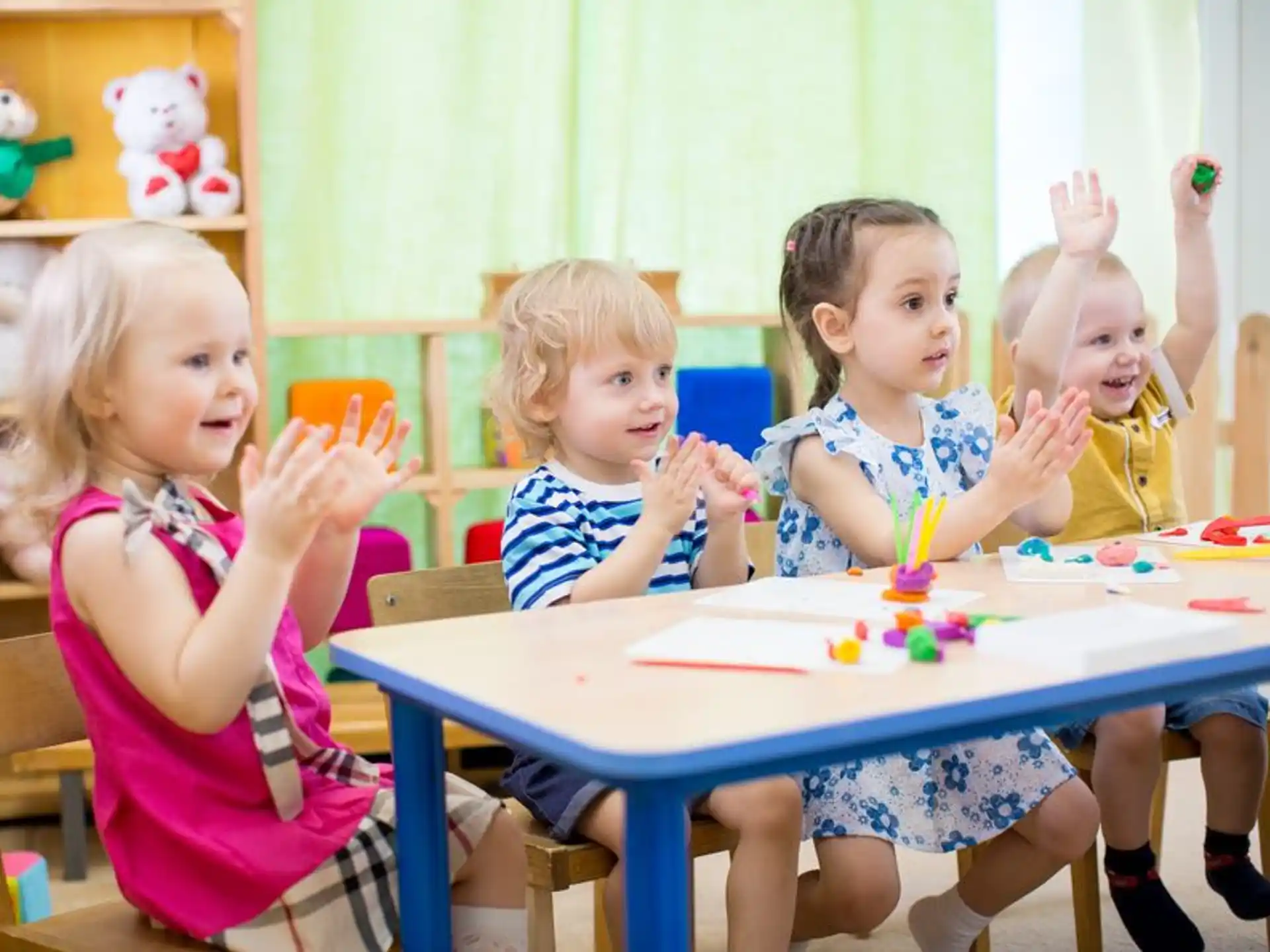 a group of children sitting at a table with a cake