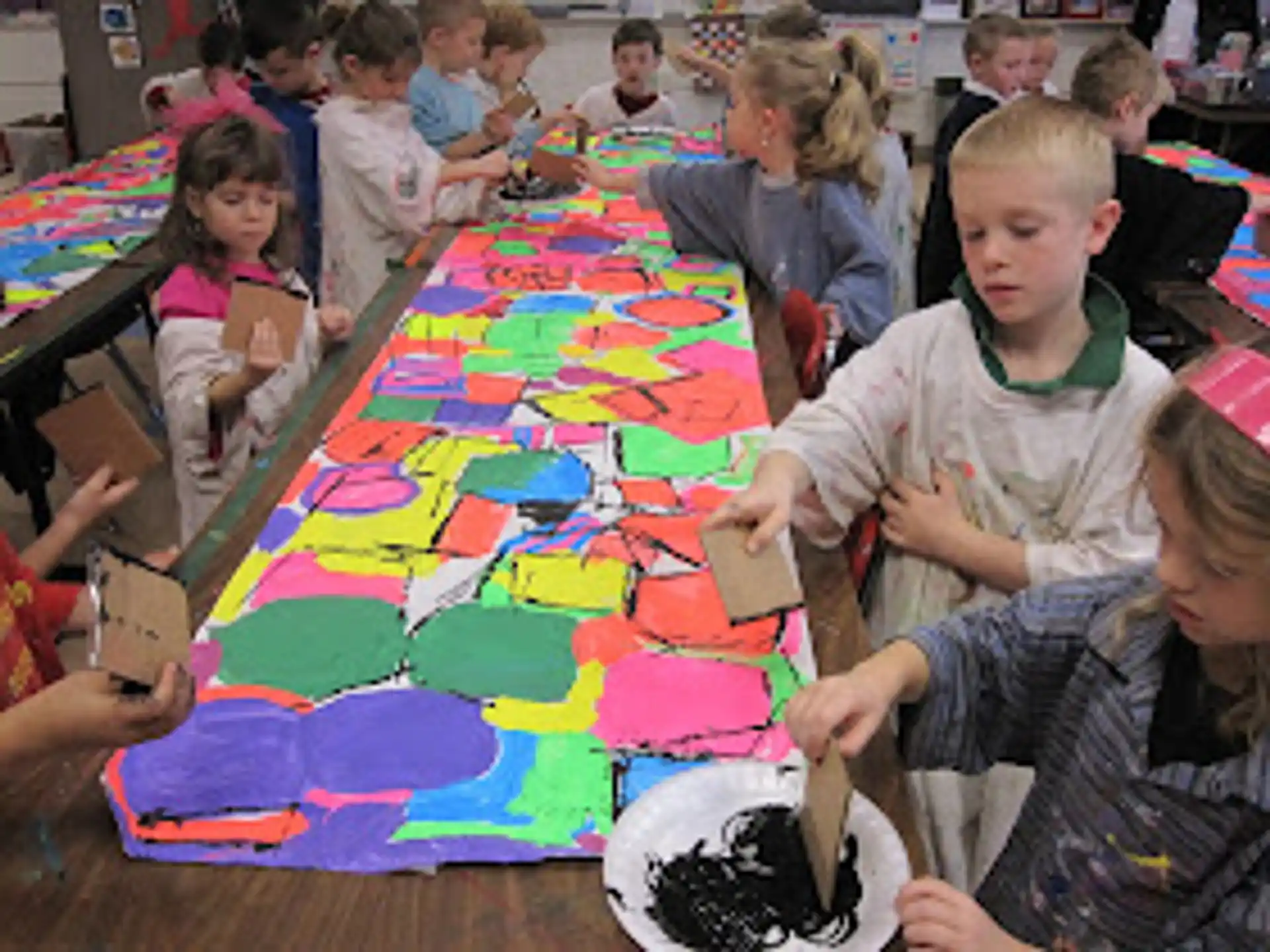 a group of children sitting at a table playing a board game
