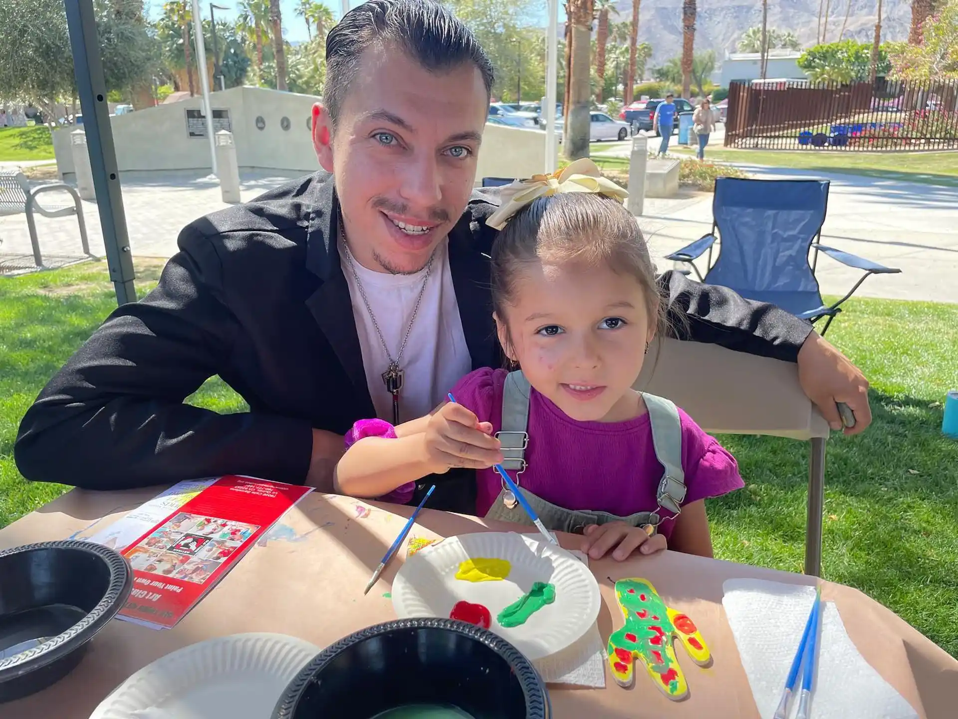 a person and a child sitting at a table with food