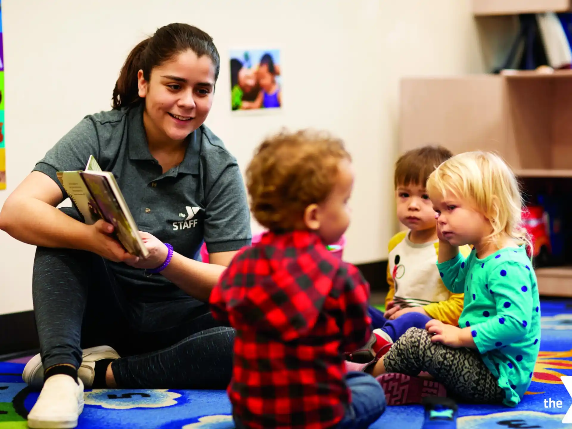 a person reading a book to a few children