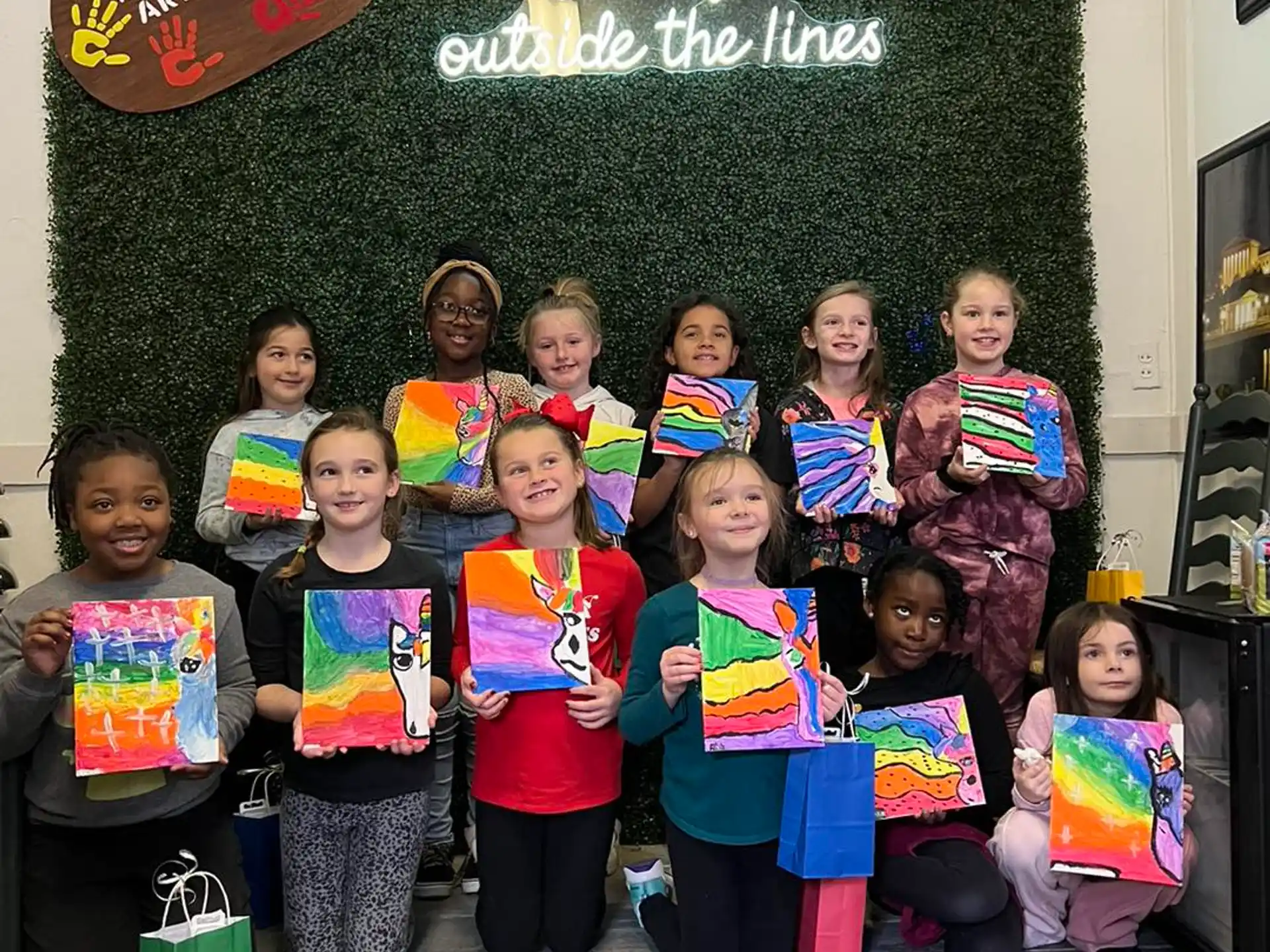 a group of children posing for a photo in front of a chalkboard