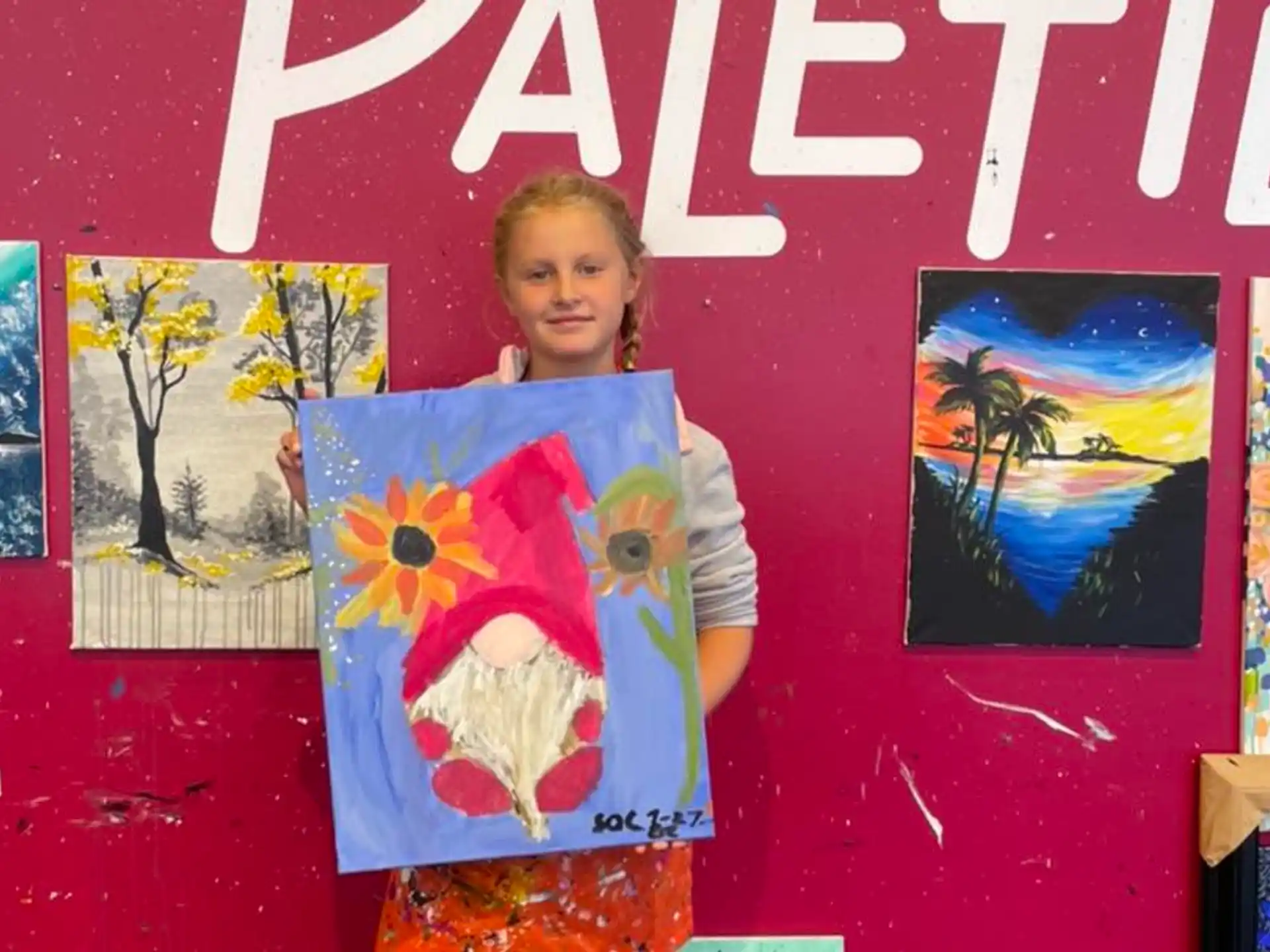 a girl standing in front of a wall with art on it