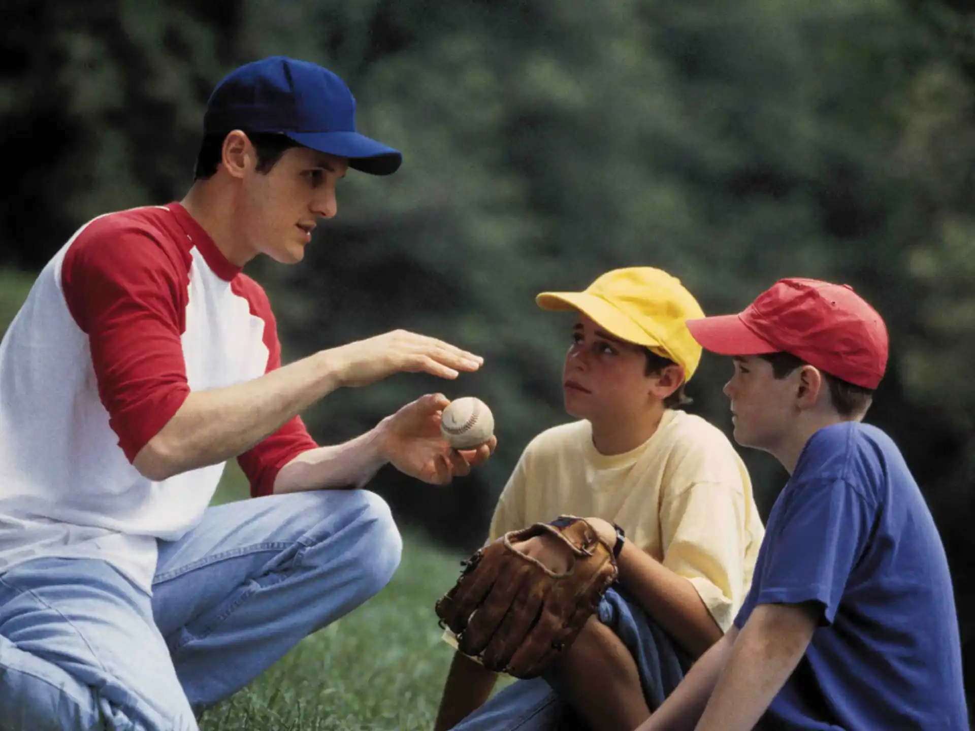 a man and a couple of kids playing baseball