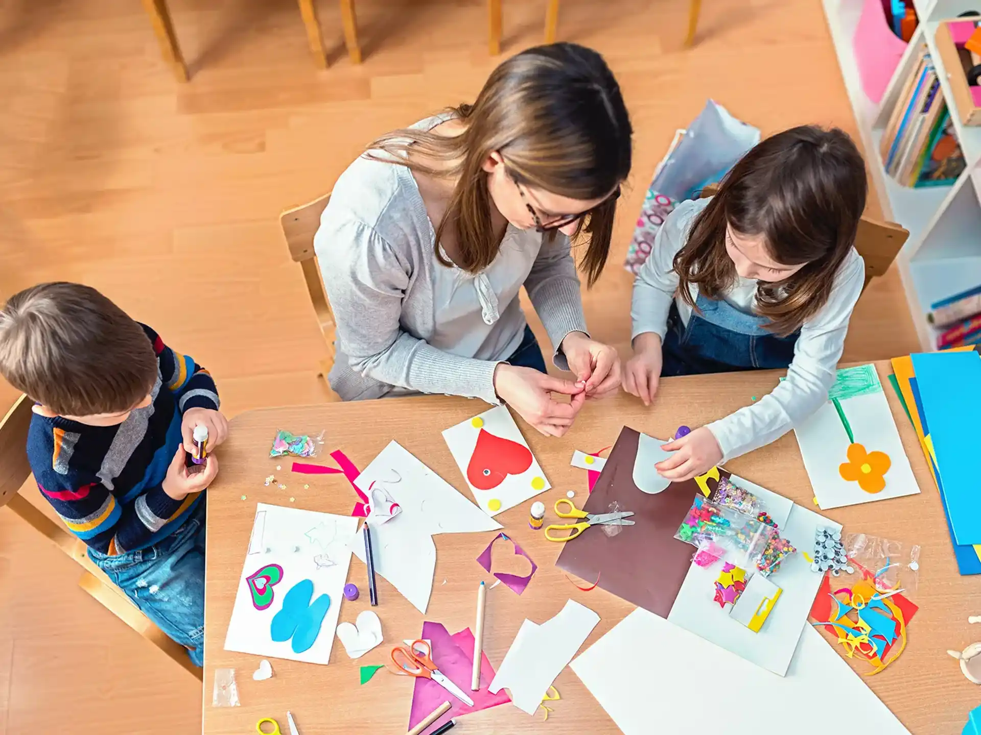 a woman and a child playing with colorful paper
