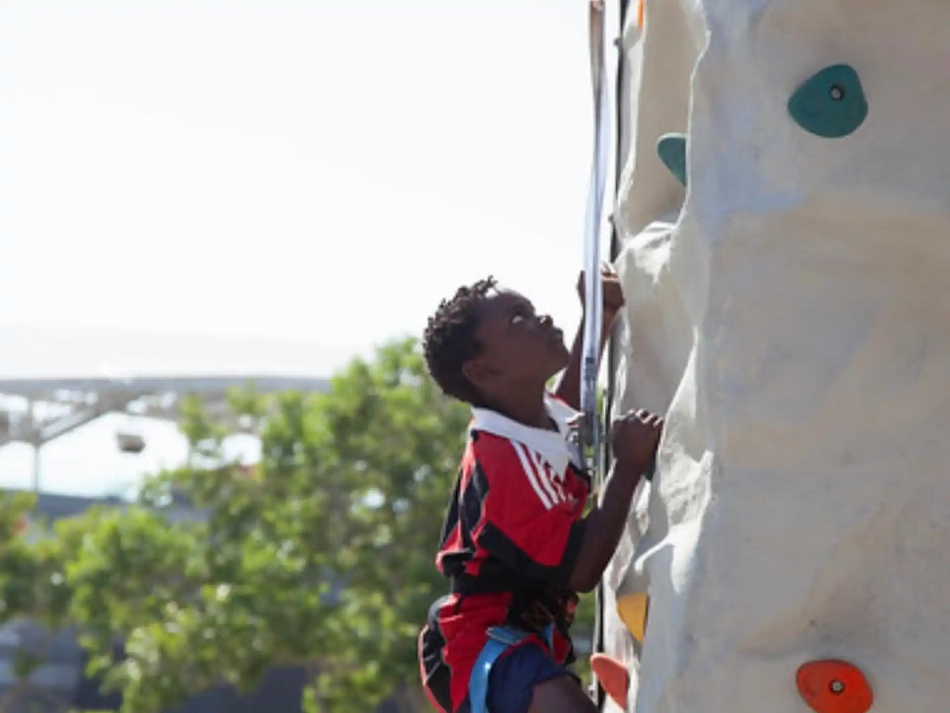 a boy climbing a rock wall