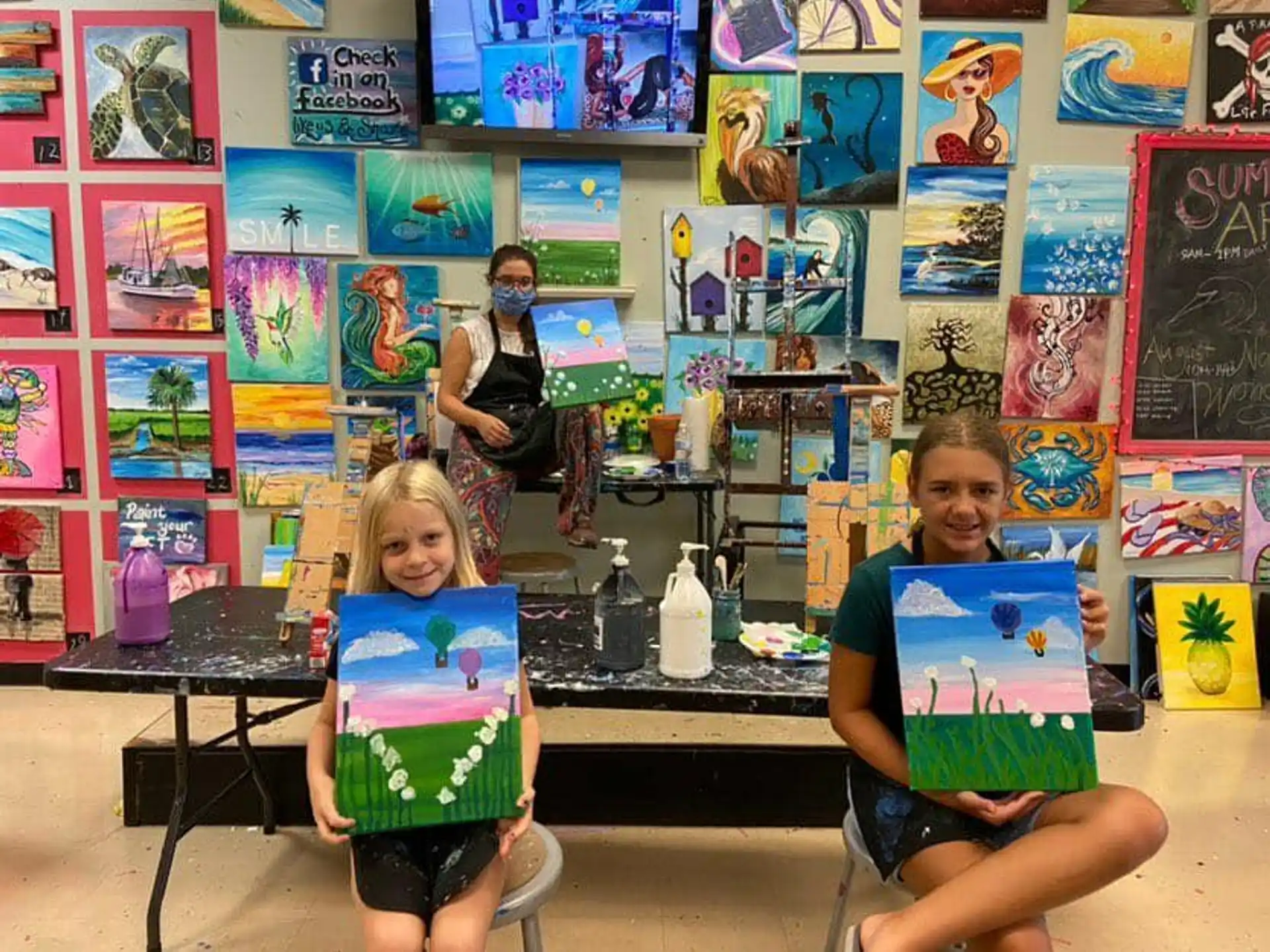 a couple of kids sitting at a table with toys