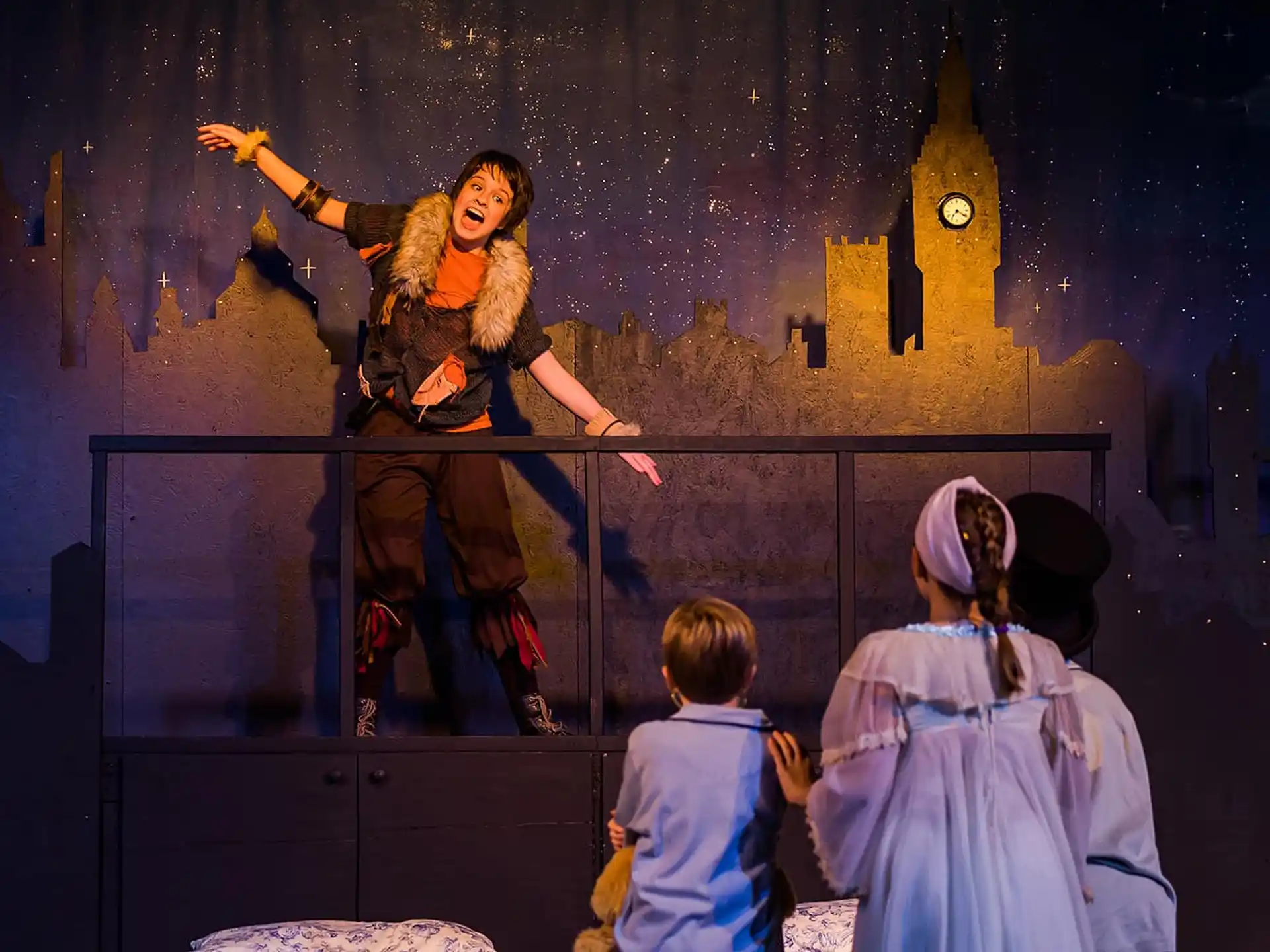 a person on stage with children