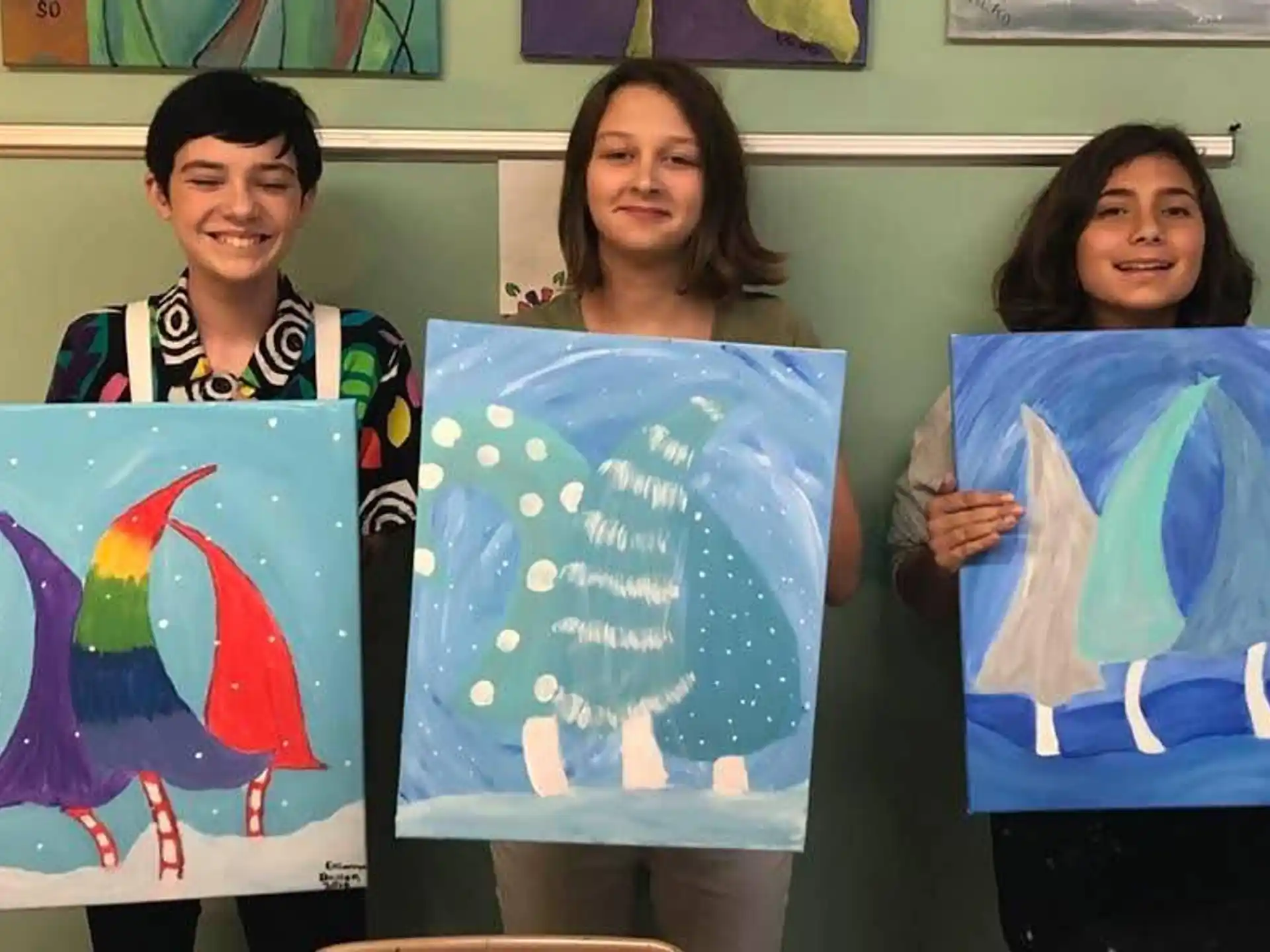 a group of women holding up paintings