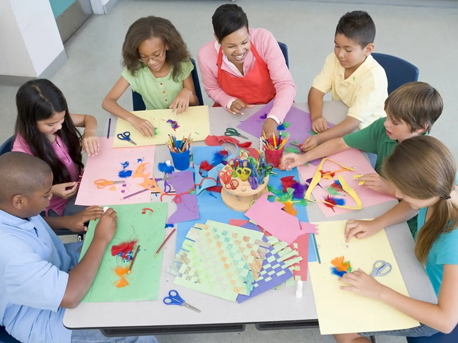 a group of children sitting around a table playing with toys