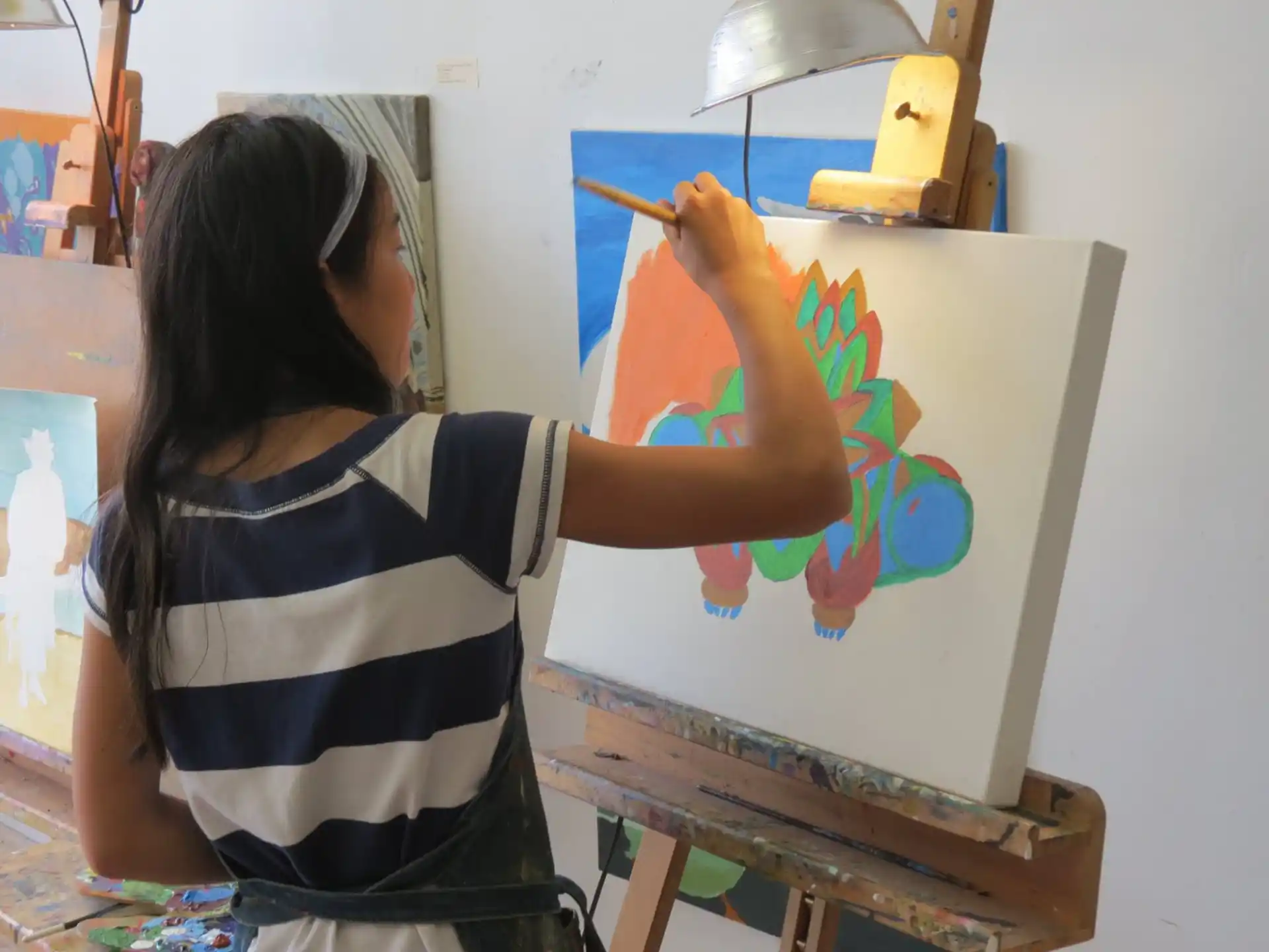 a woman painting on a white board