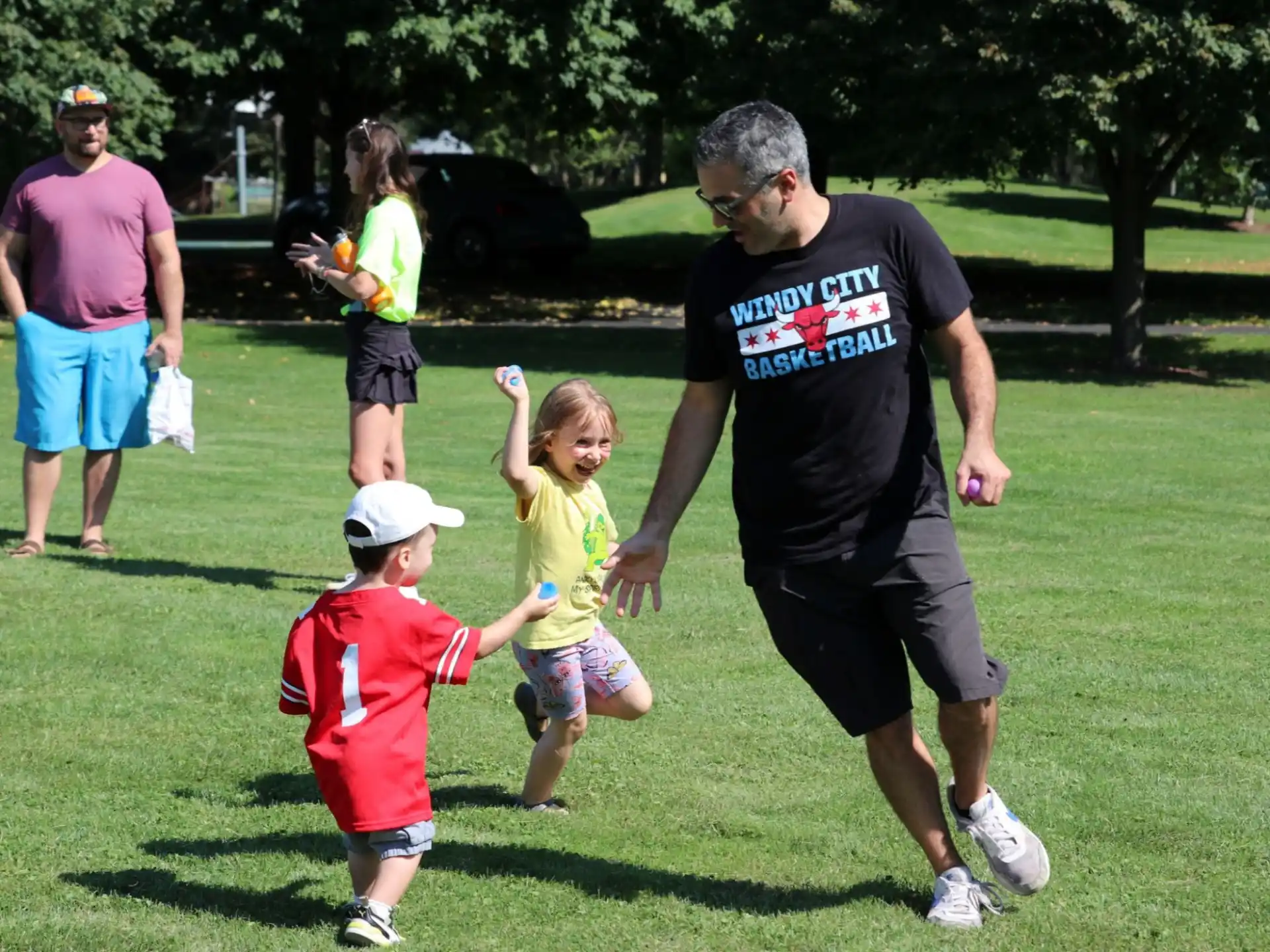a man and a couple of kids playing with a man and woman