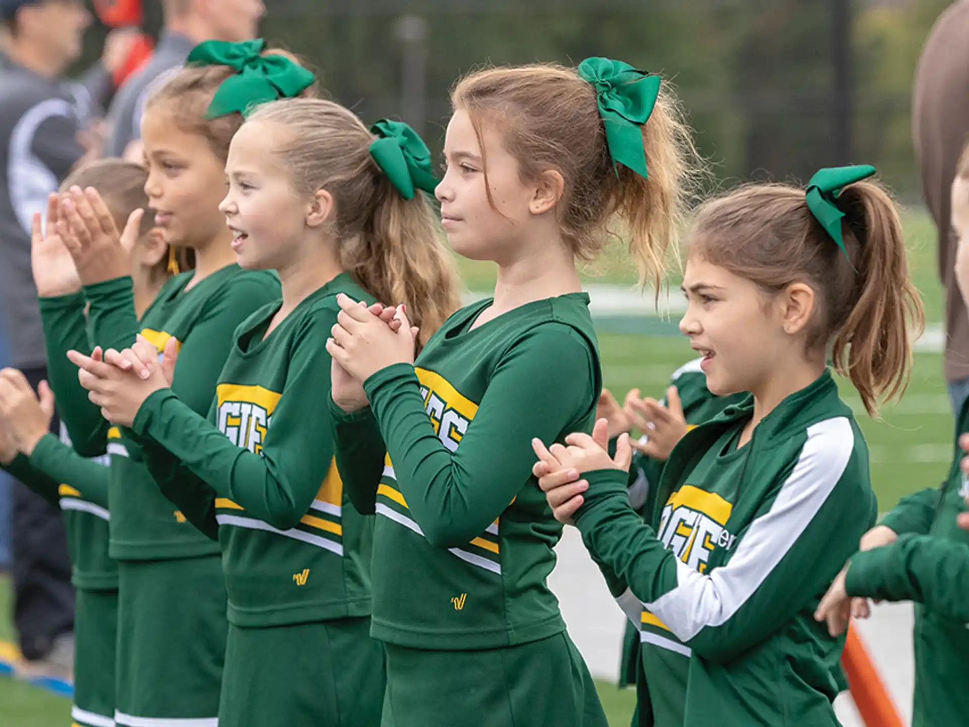 a group of girls in green uniforms
