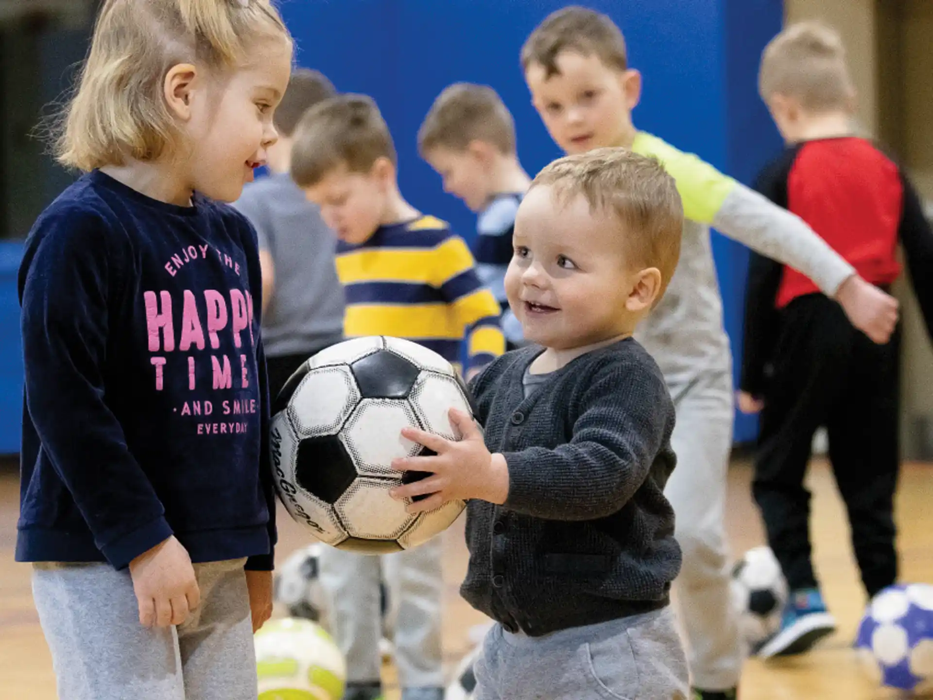 a group of kids playing with a football ball