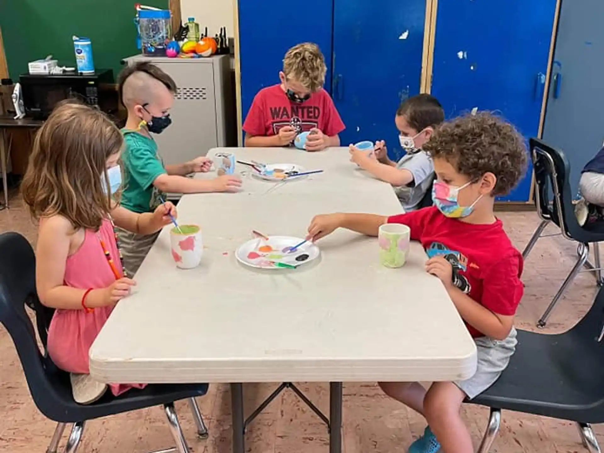 a group of children sitting around a table