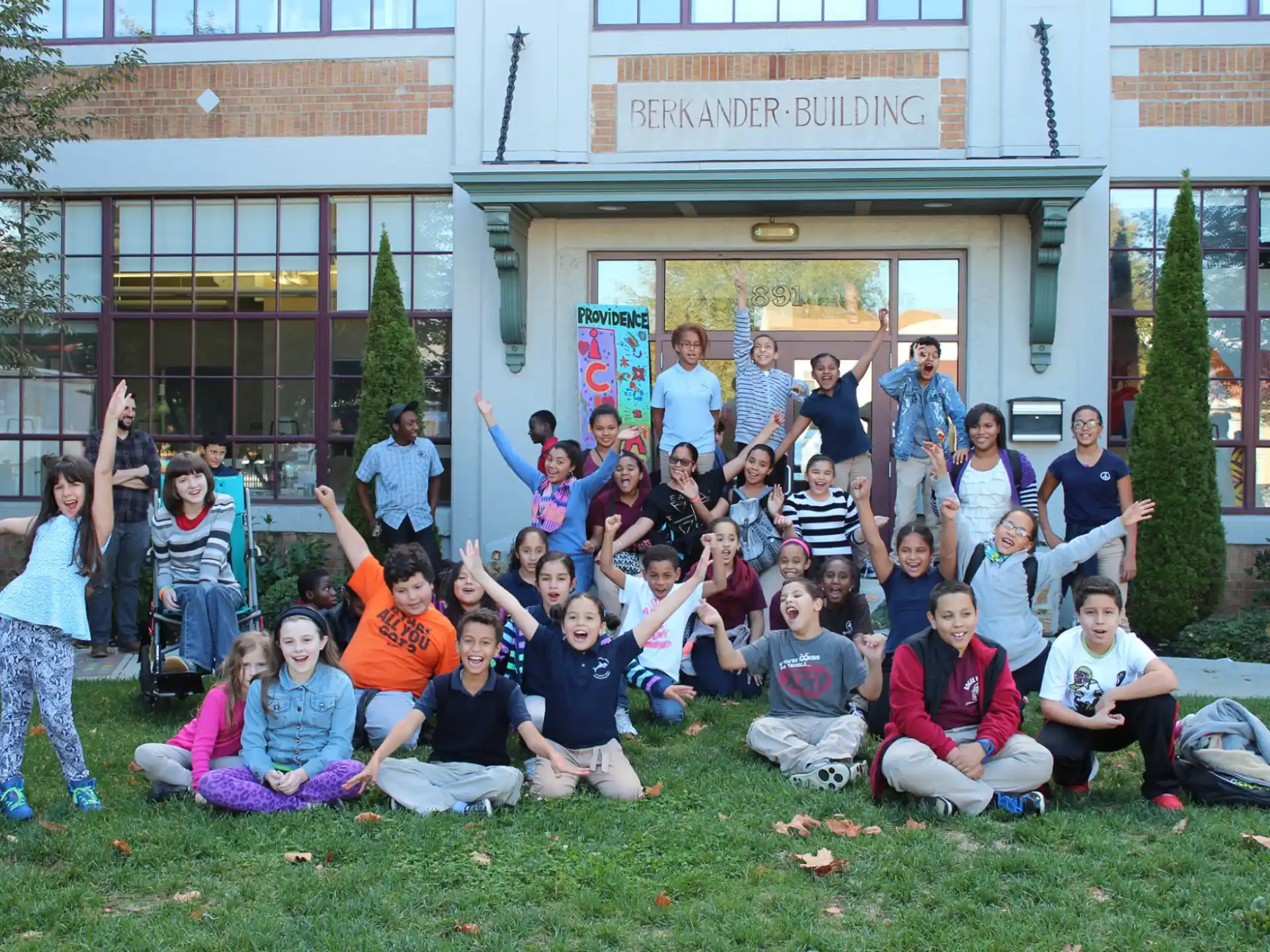 a group of people posing for a photo in front of a building