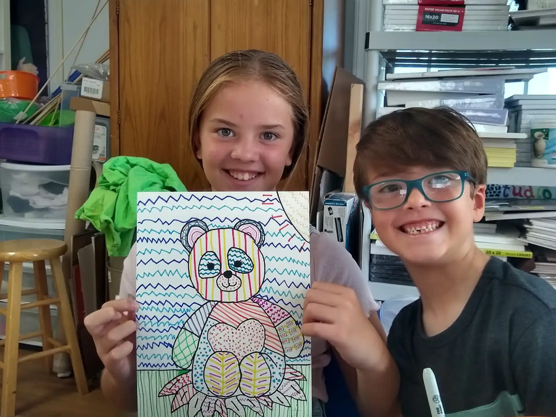 a boy and girl holding up a picture of a boy