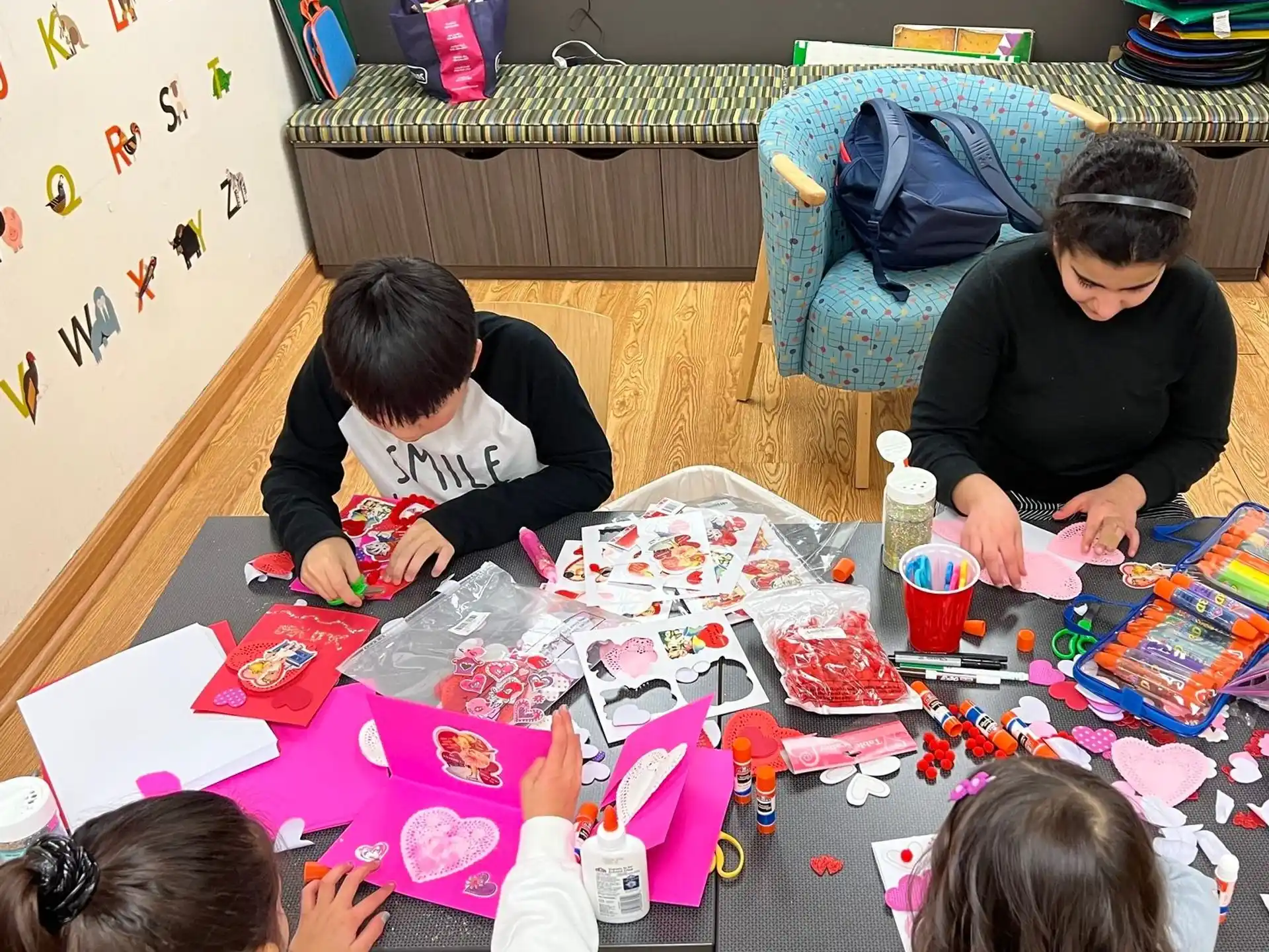 a group of children sitting around a table with a cake on it