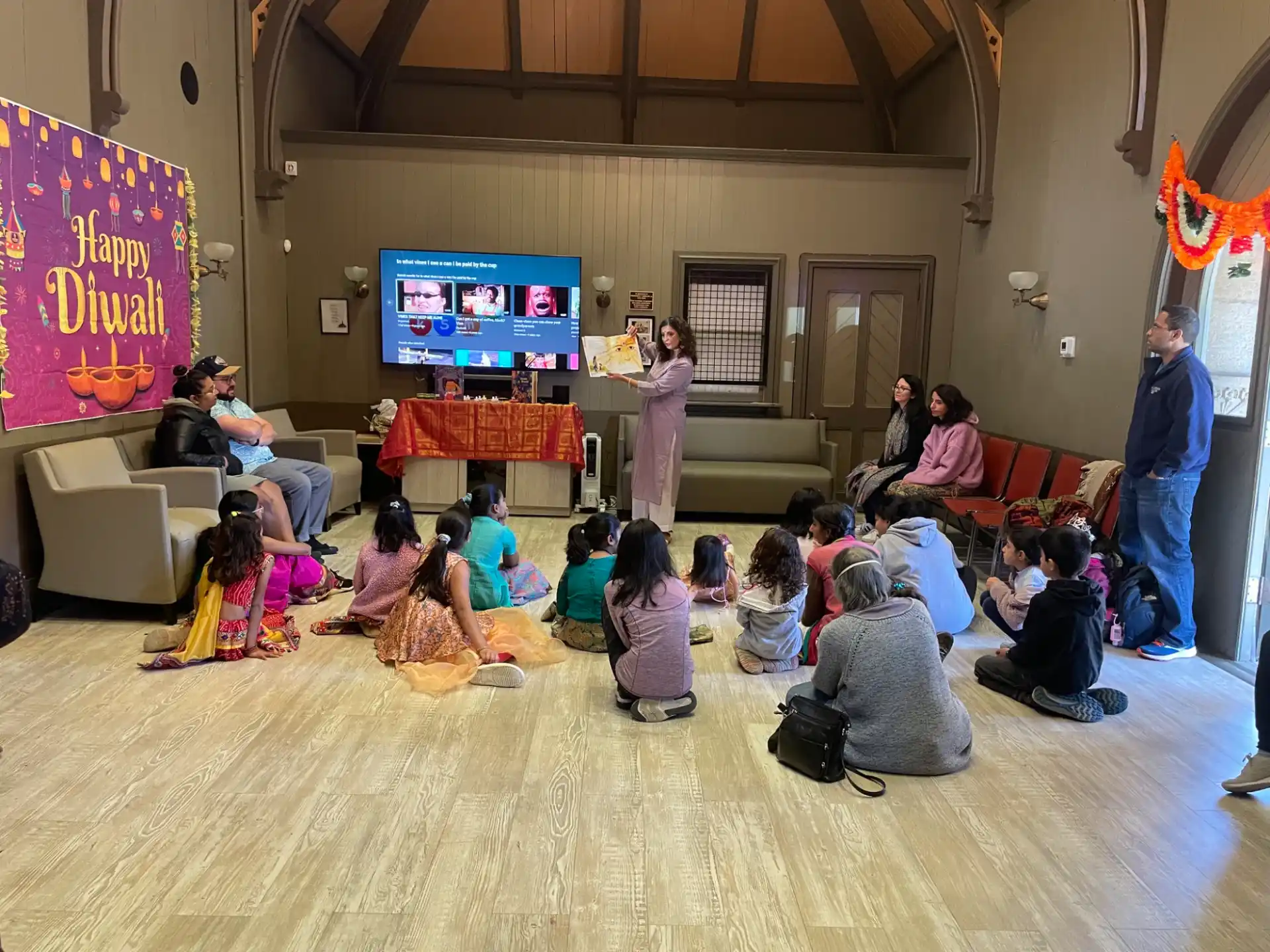 a group of people sitting in a room watching a television