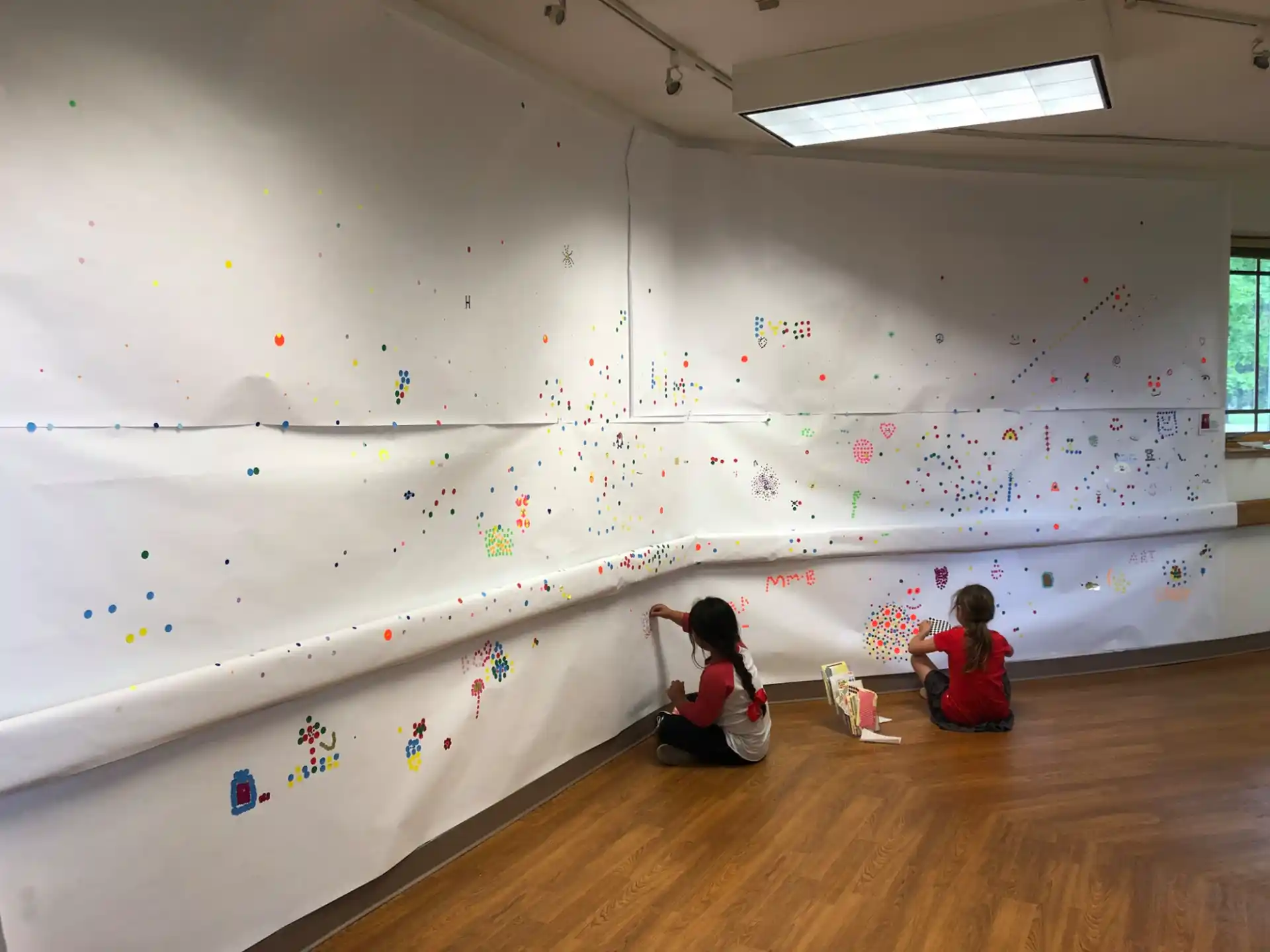 a couple of kids painting on a wall