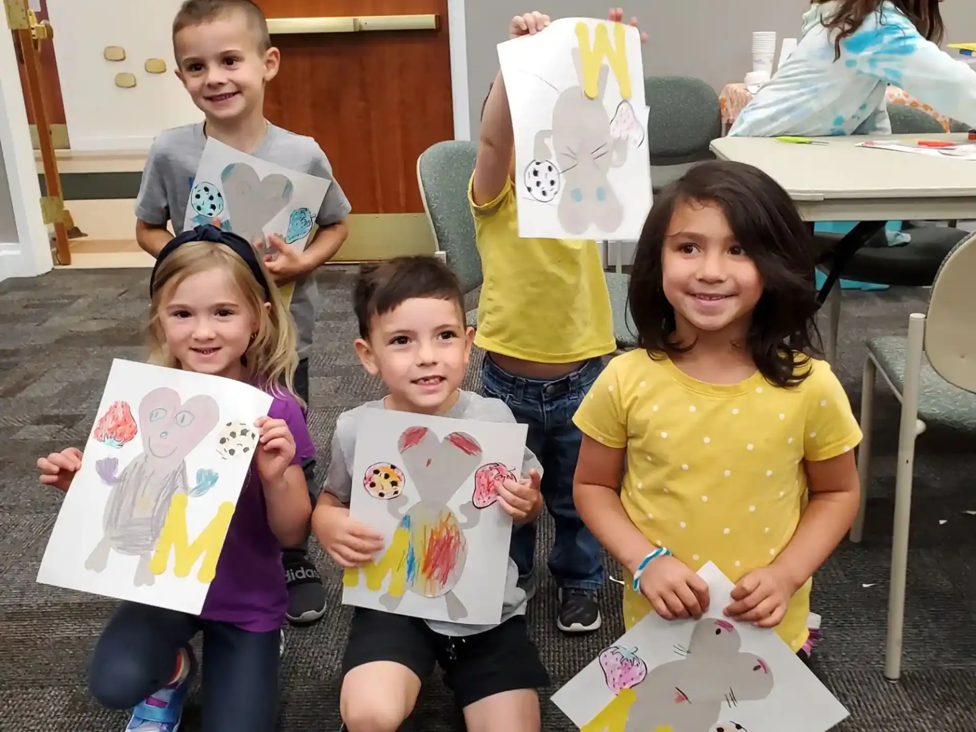 a group of children holding up paper bags