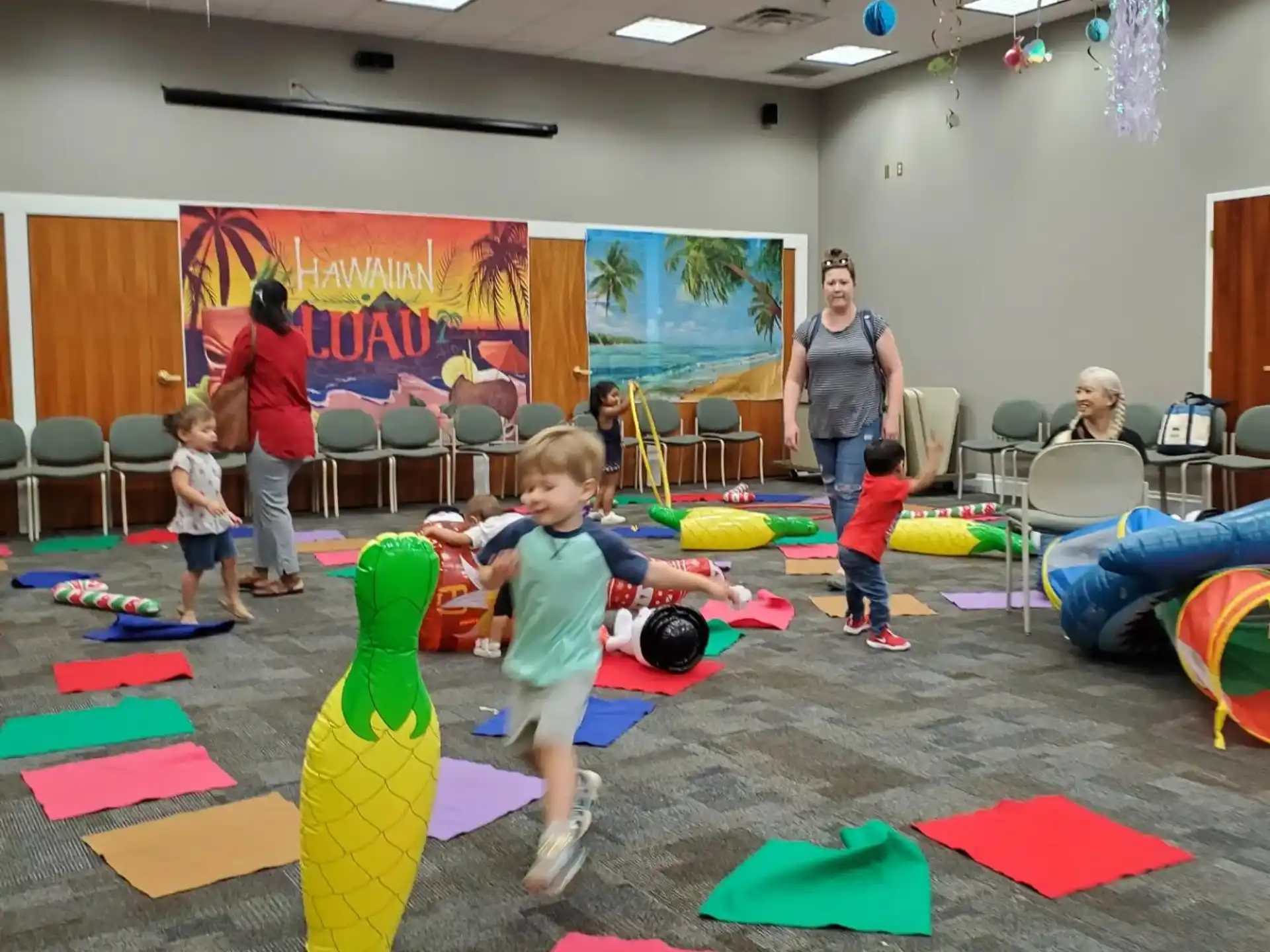 a group of children playing in a room with colorful mats