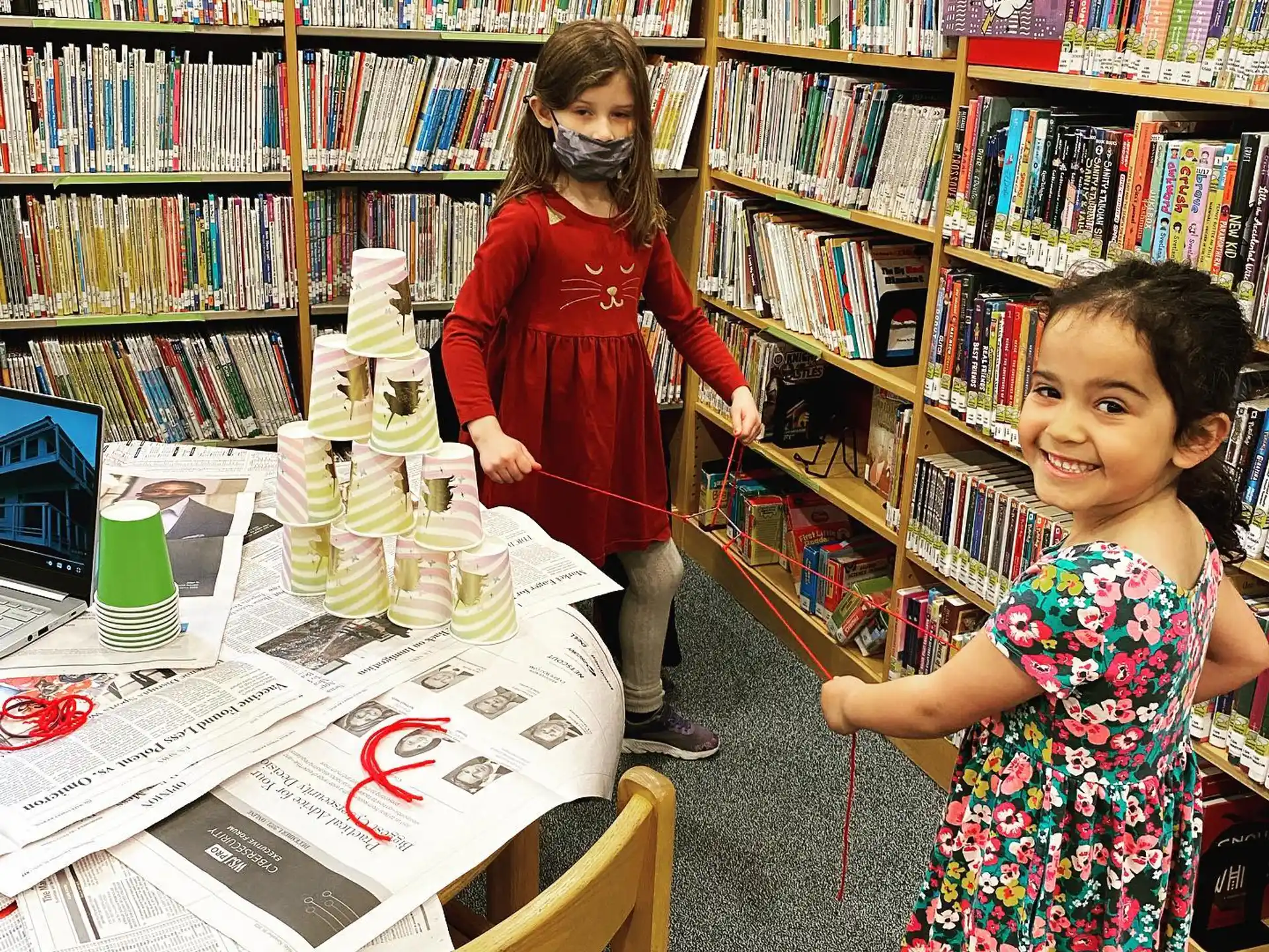 a couple of girls in a library