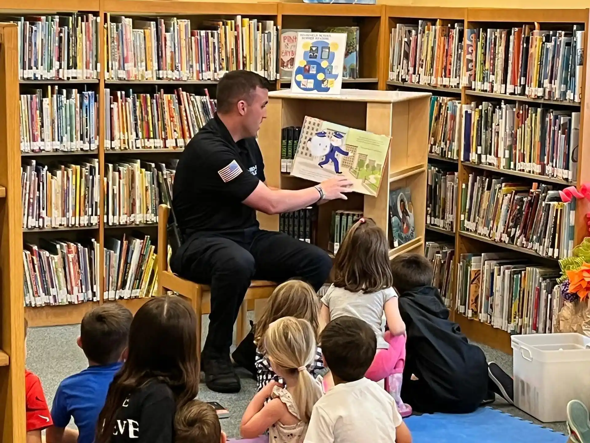 a person reading a book to a group of children