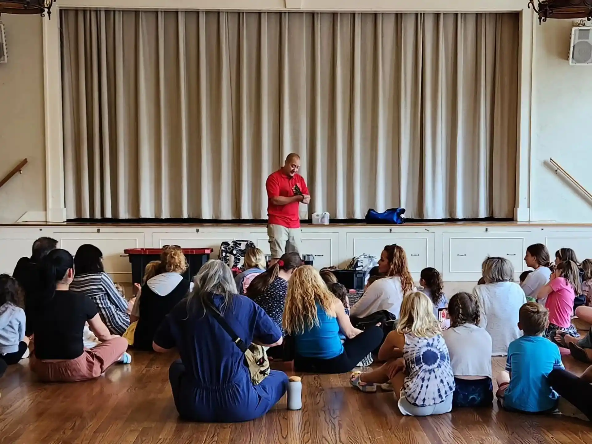 a person standing in front of a group of people sitting on the floor