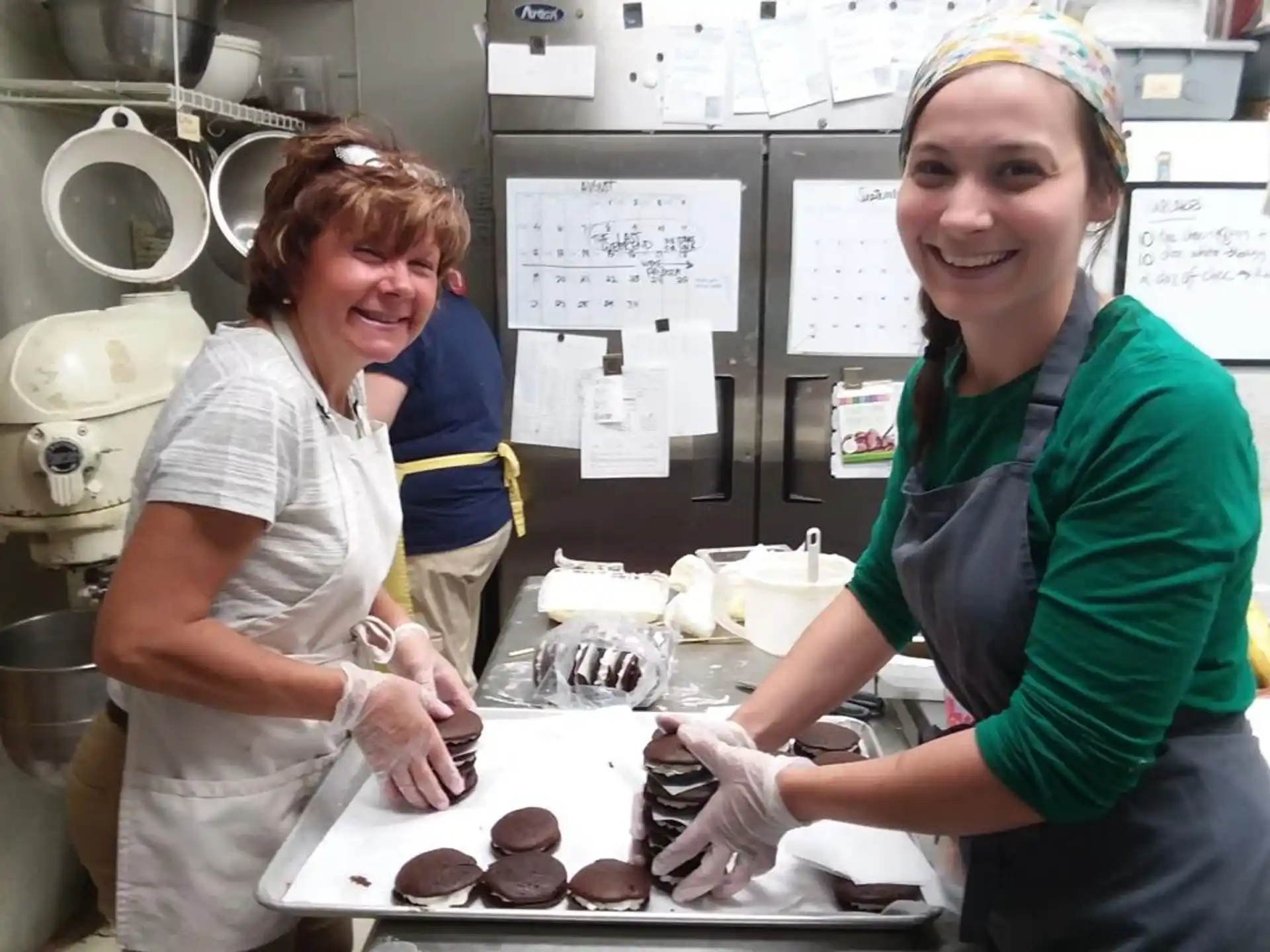 women in a kitchen making donuts