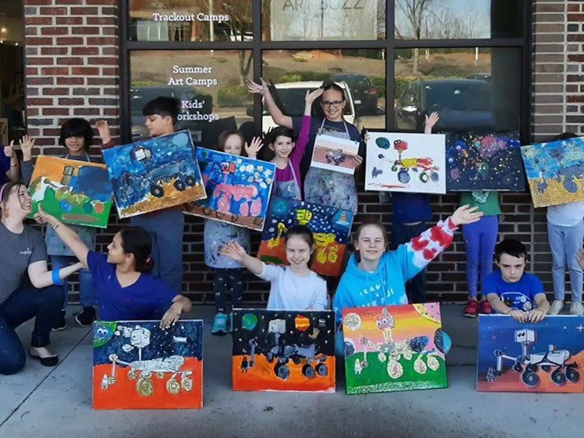 a group of kids holding up colorful boxes