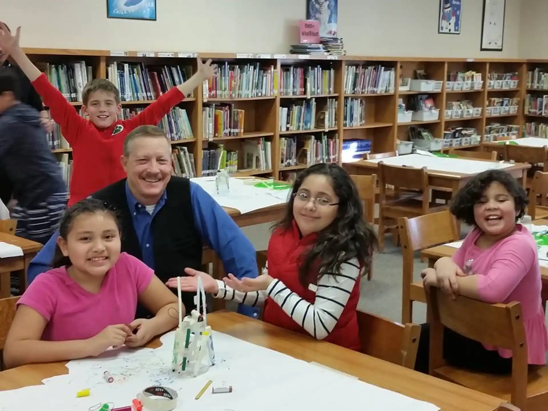 a group of people sitting at a table with a toy