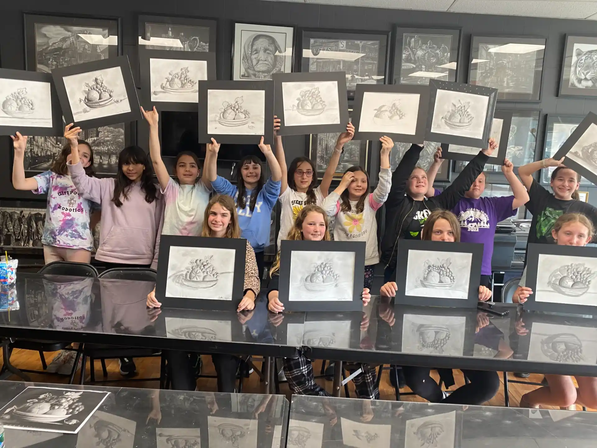 a group of people holding up framed pictures