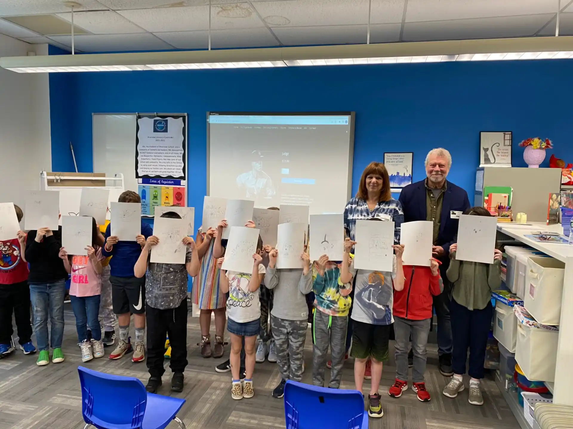 a group of people standing in a room with blue walls and white signs
