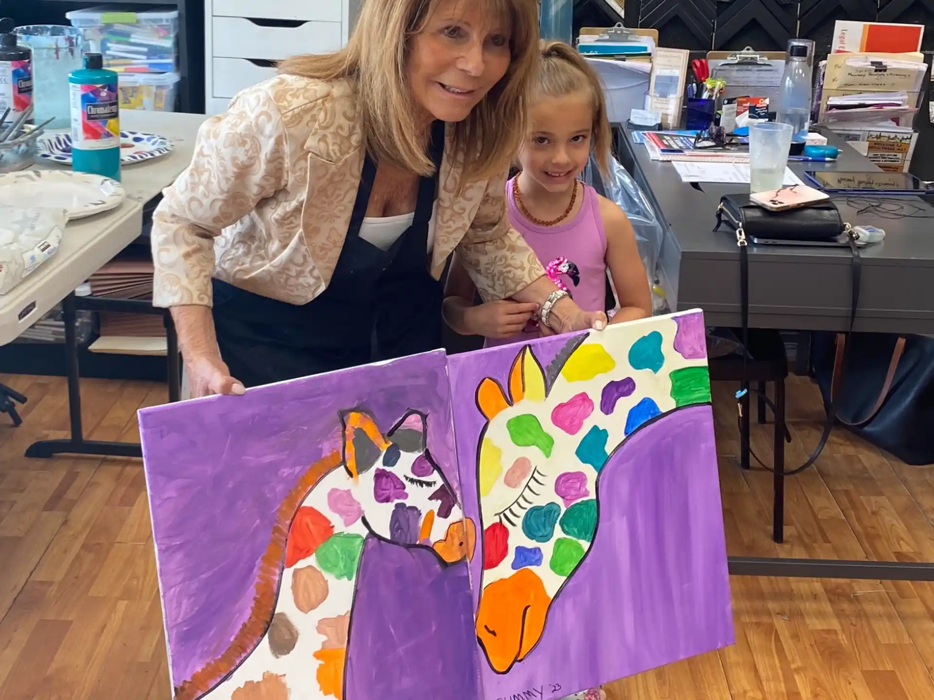 a person and a girl holding a large piece of art