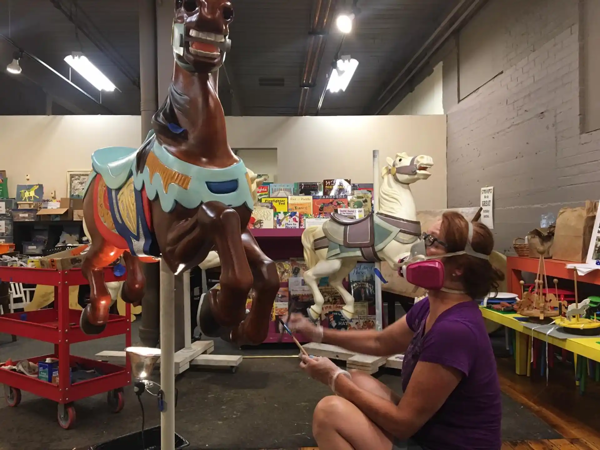 a woman working on a horse statue