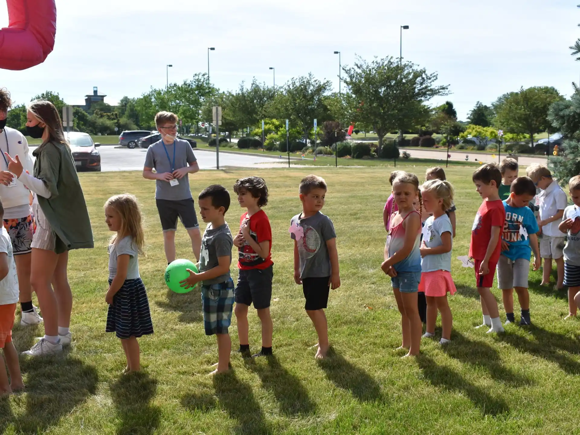 a group of children standing in a grassy field