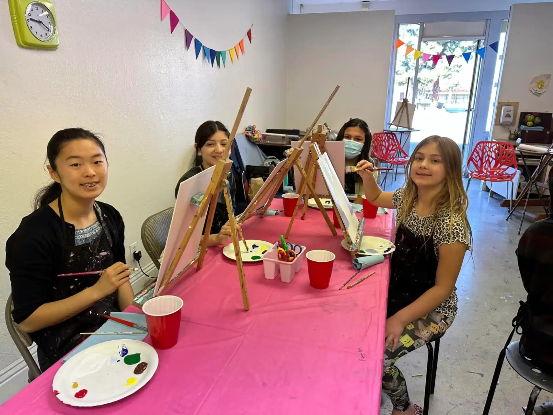a group of women sitting at a table with food and drinks