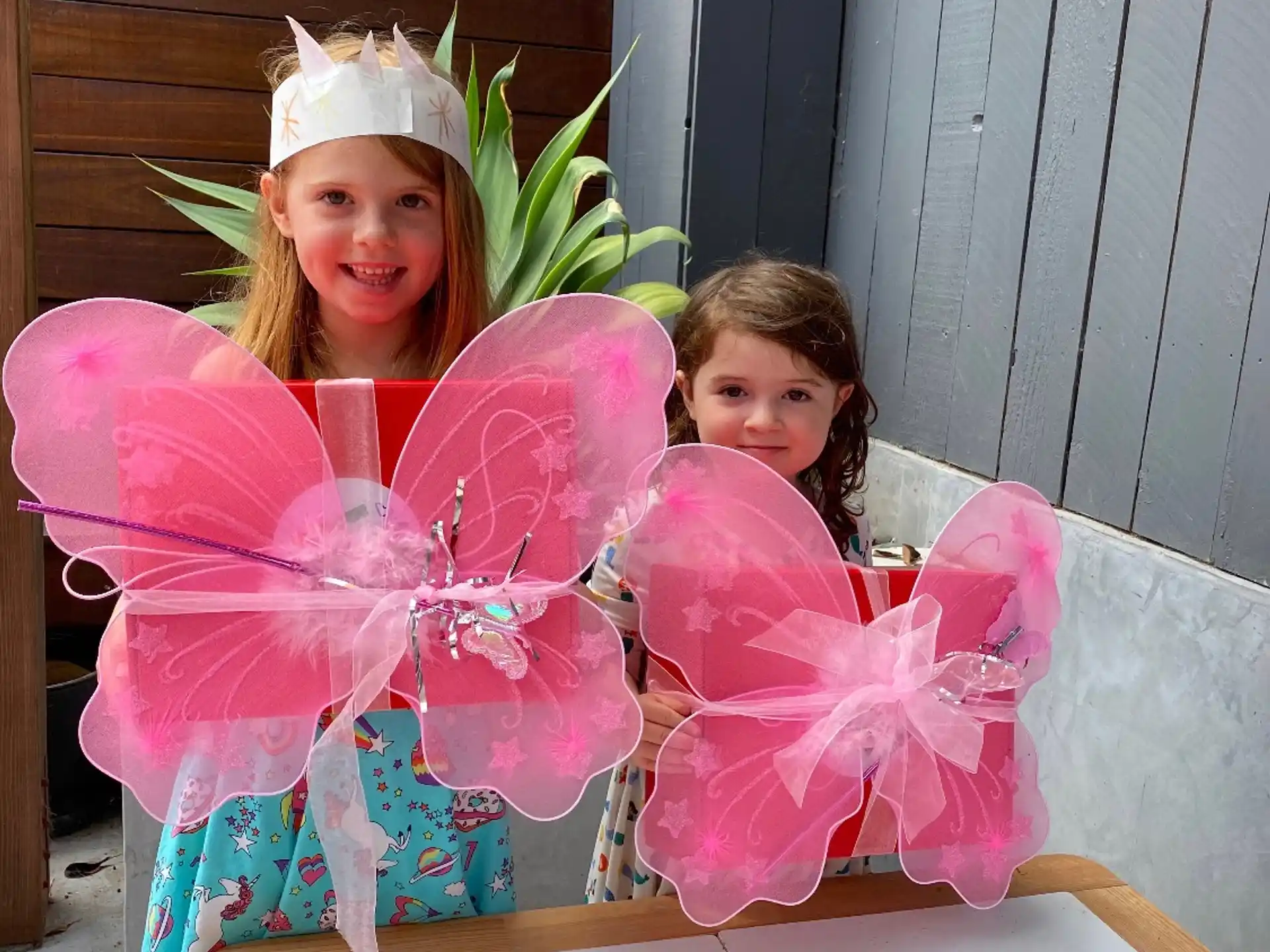 a couple of girls in a basket with pink flowers