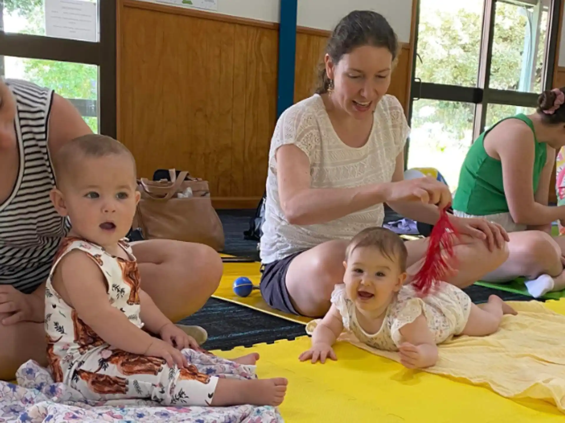 a woman and several children sitting on a yellow blanket