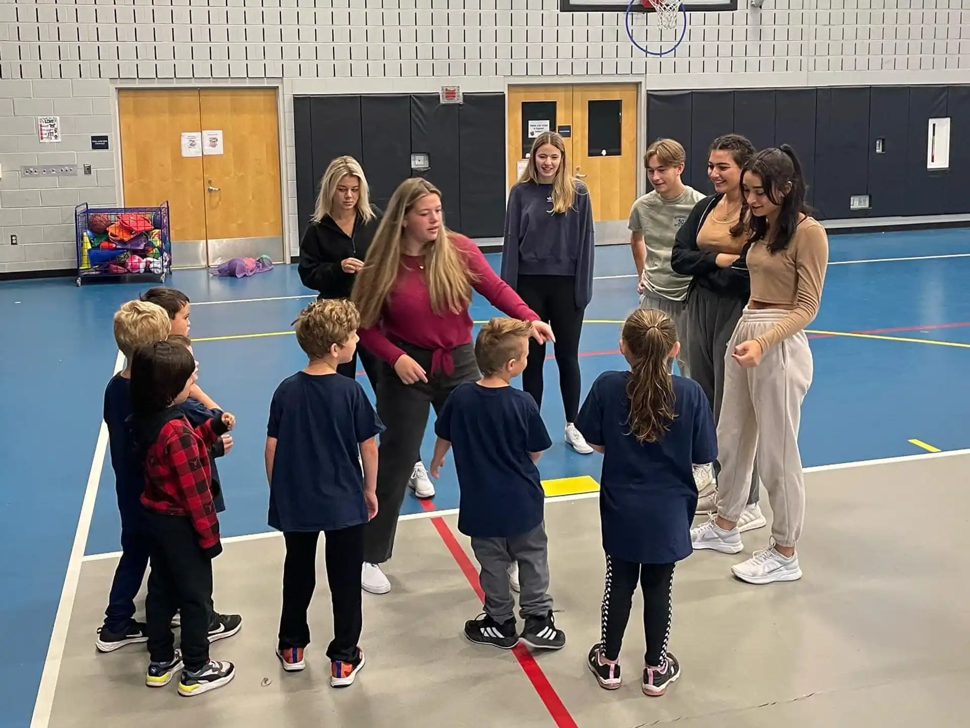 a group of people standing in a room with a person and a group of children