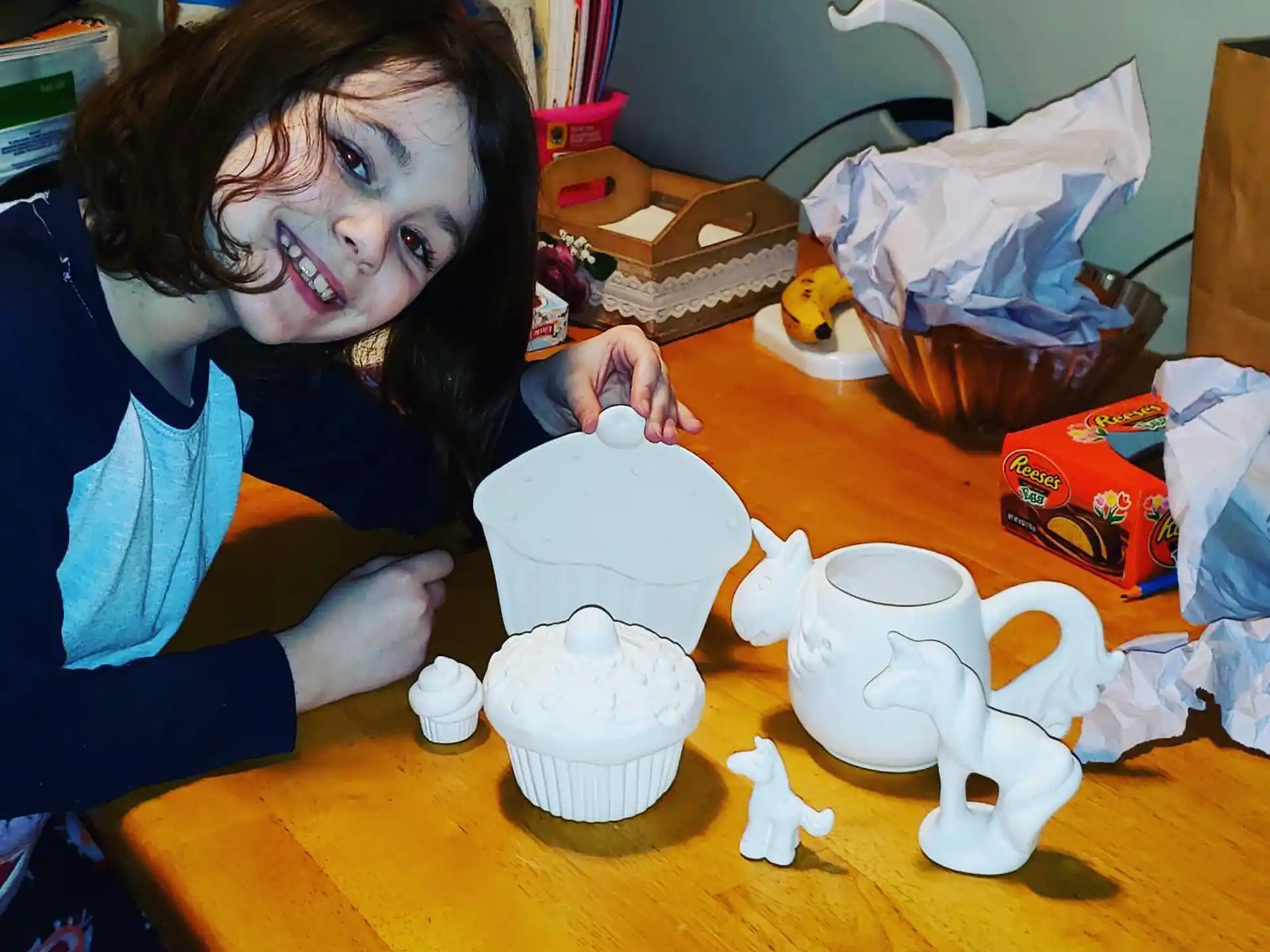 a person sitting at a table with a tea set and a cup