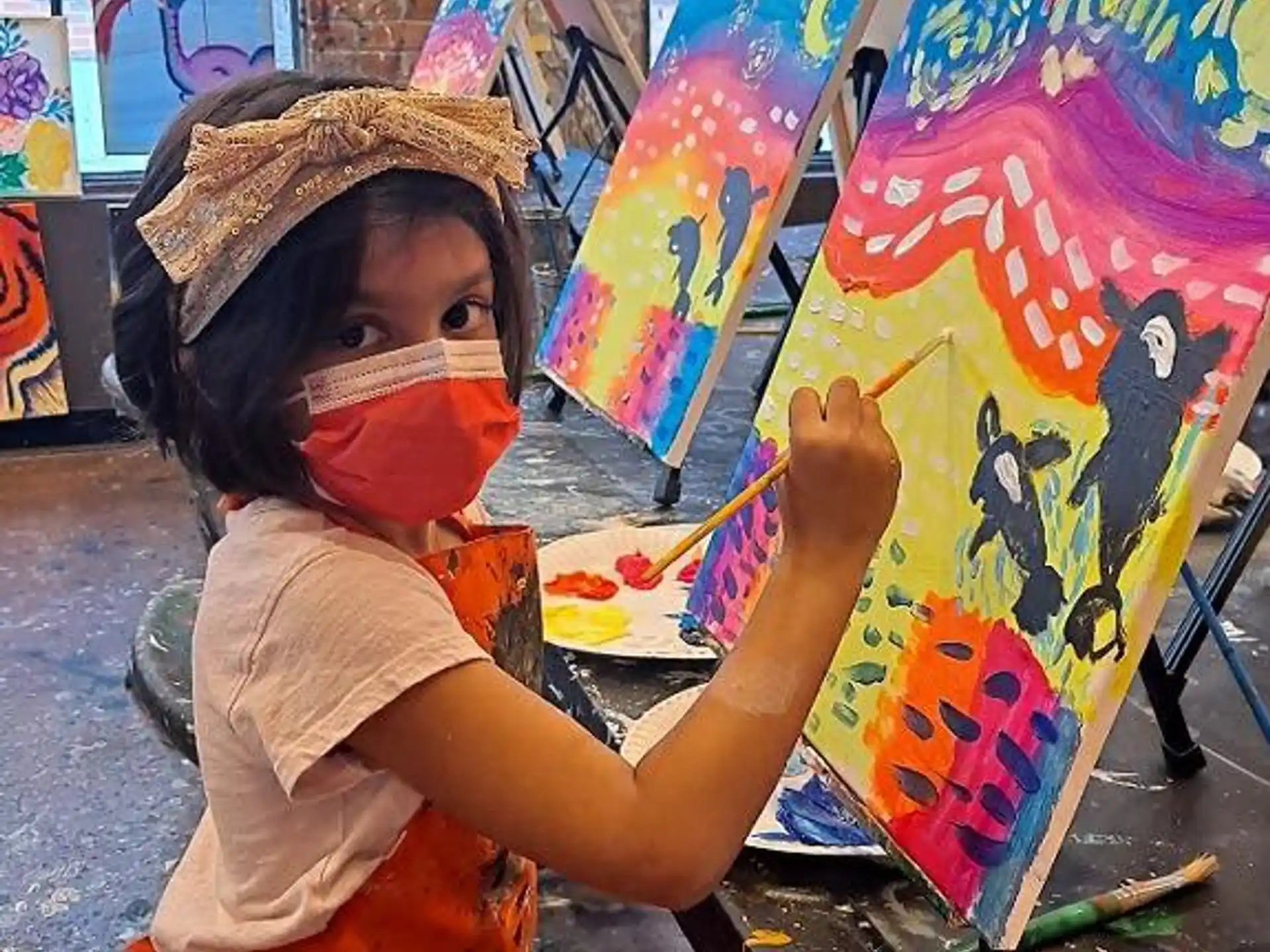 a young boy painting on a wall