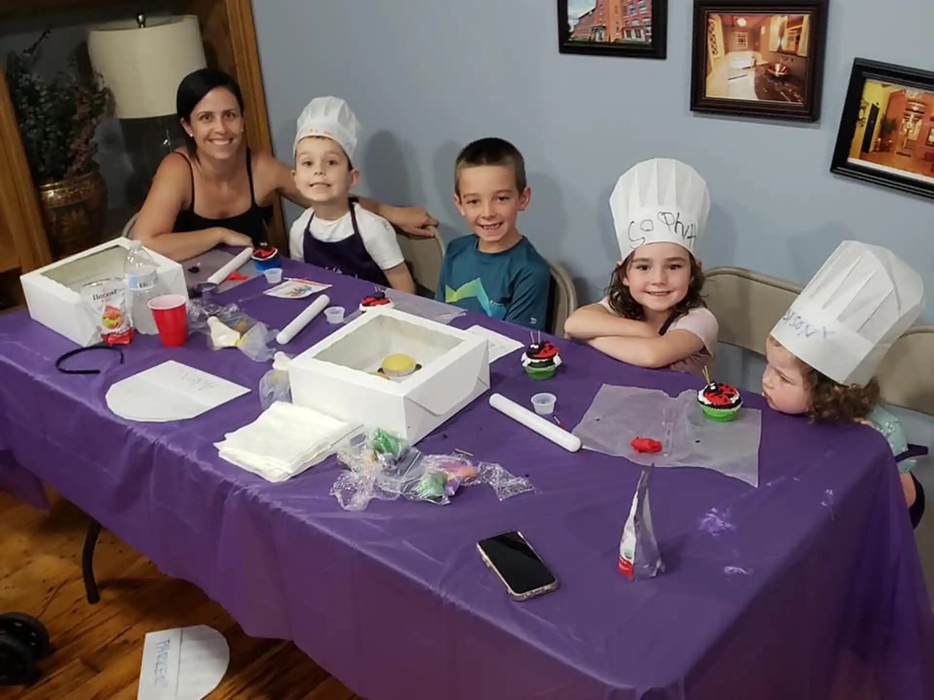 a group of children sitting at a table with a blue tablecloth