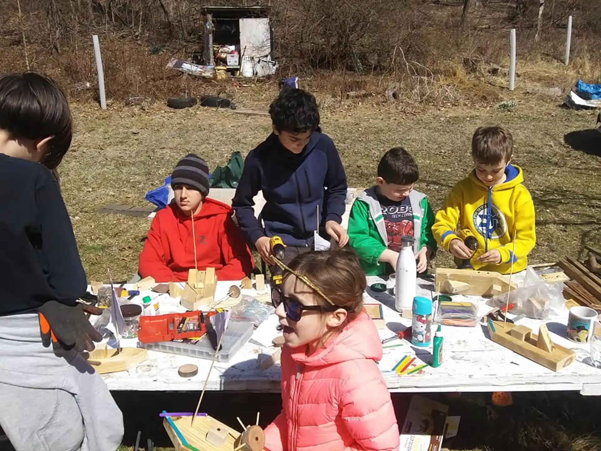 a group of people sitting around a table outside