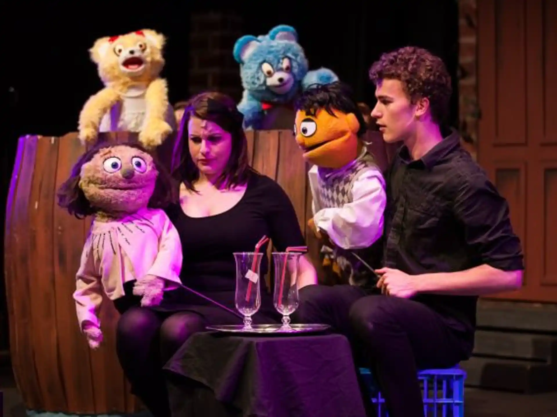a group of people sitting on a bench with stuffed animals