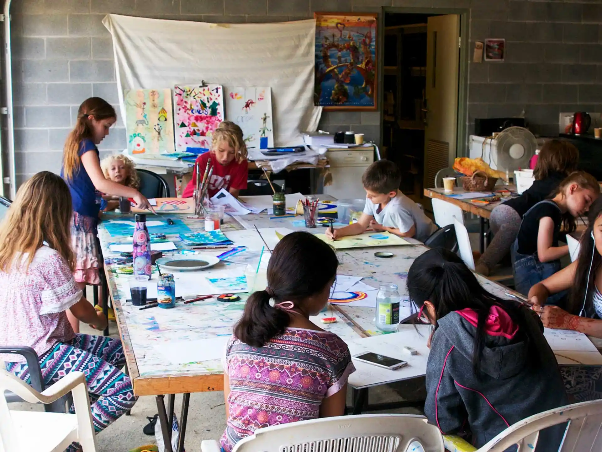 a group of children sitting around a table