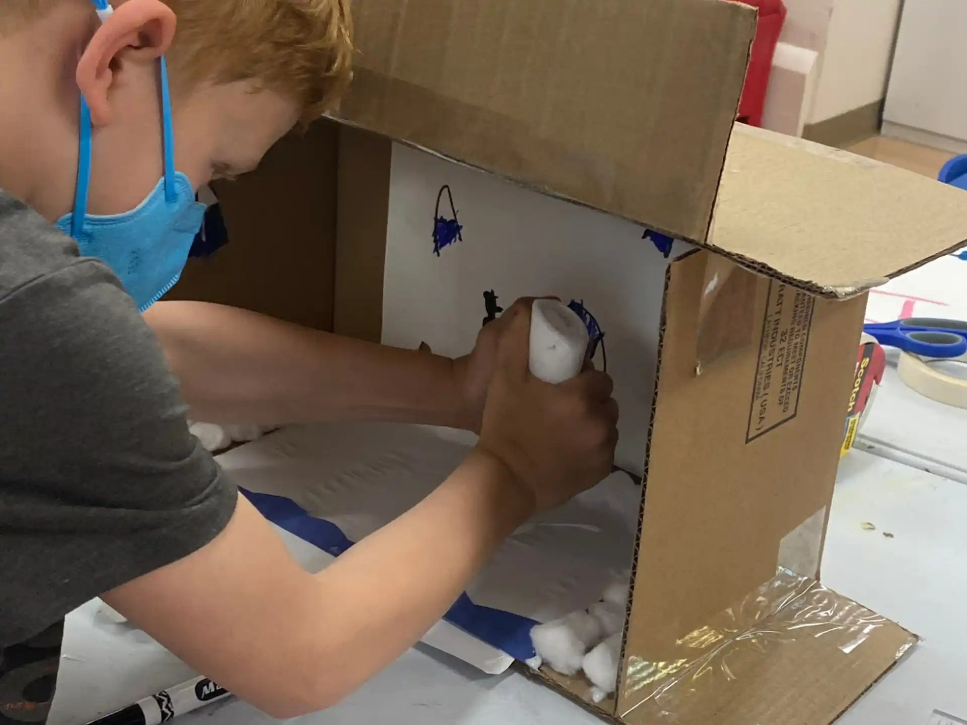 a person wearing headphones and holding a box with a white object