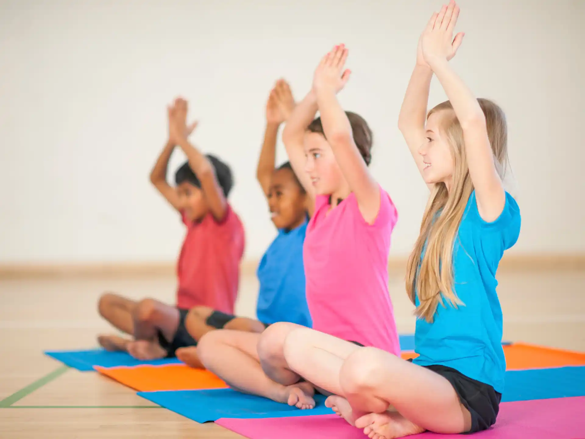a group of children raising their hands