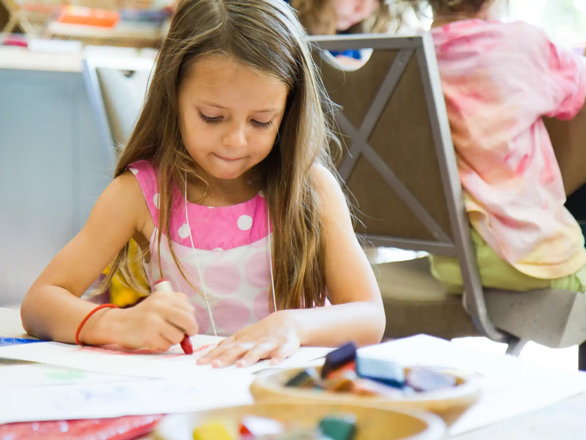 a young girl writing on a piece of paper