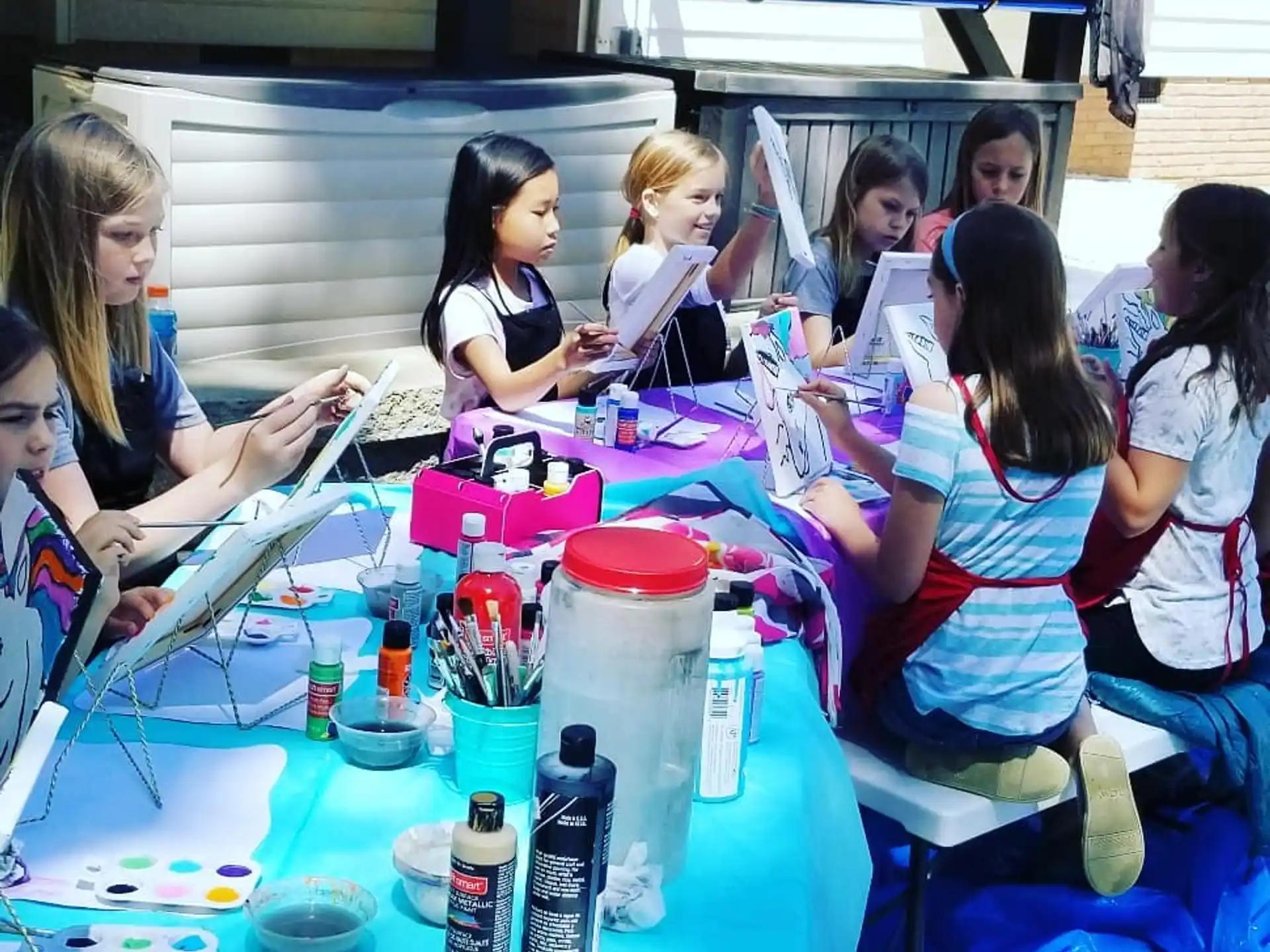a group of people sitting at a table with a blue tablecloth